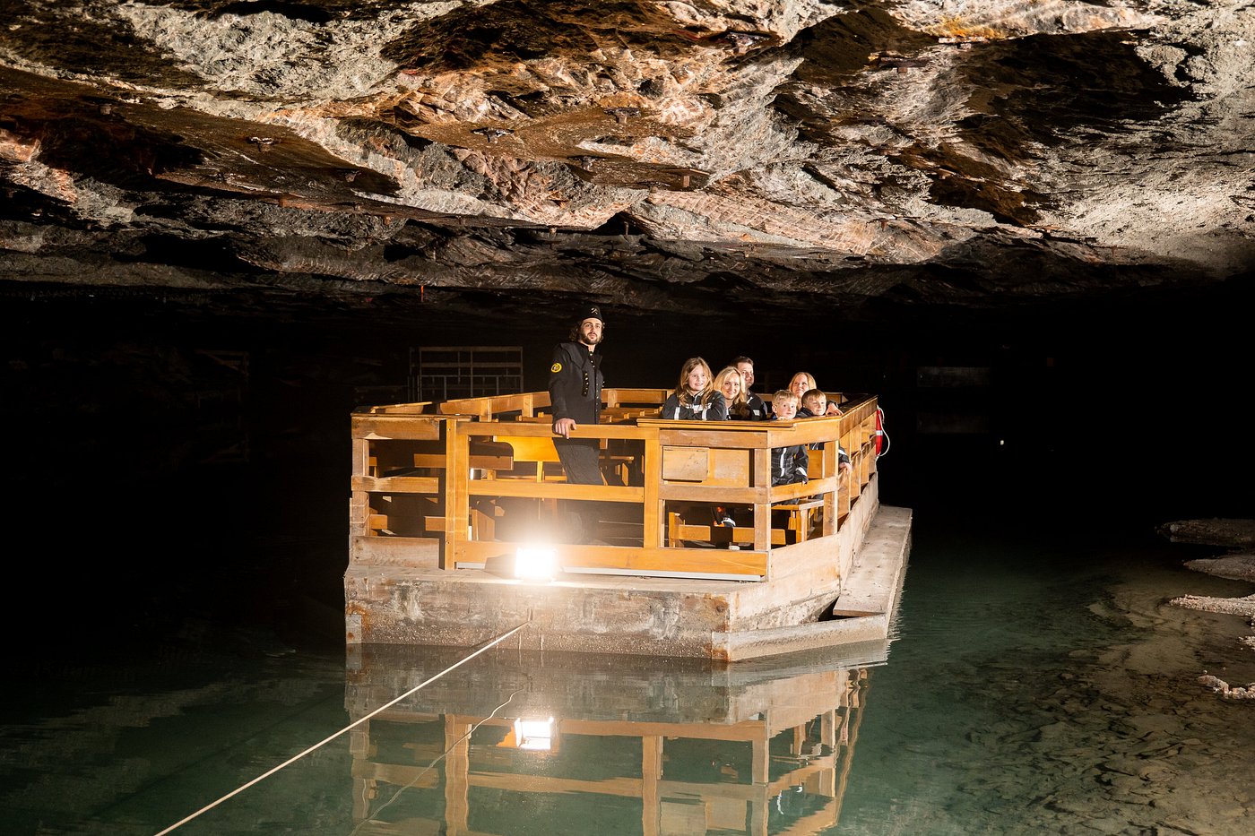 Visitors riding a wooden boat across an underground of Berchtesgaden Salt Mine