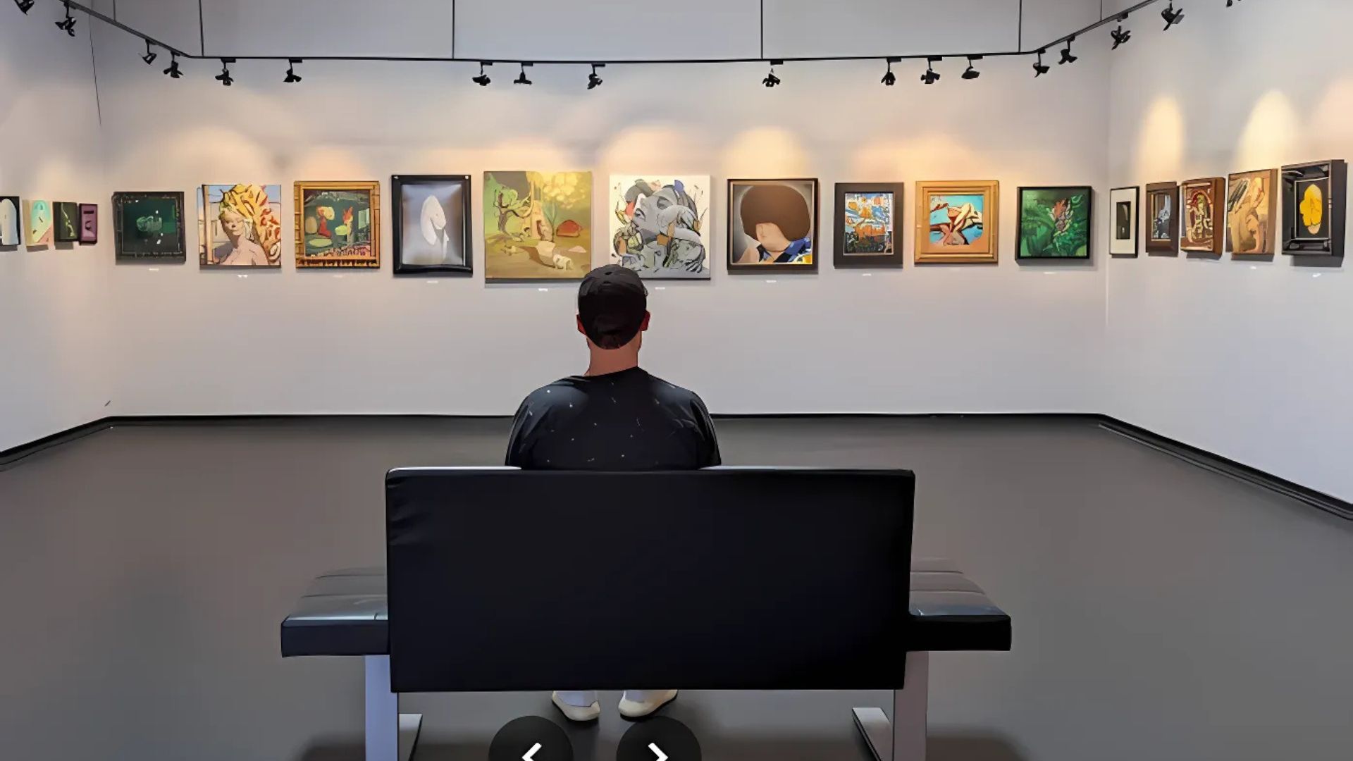 A man sitting at the bench looking at the paintings in Bergamot Station Arts Center in Santa Monica, California.
