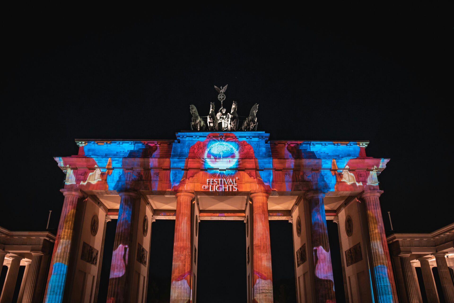 Brandenburg Gate illuminated with colorful light projections during the Berlin Festival of Lights.
