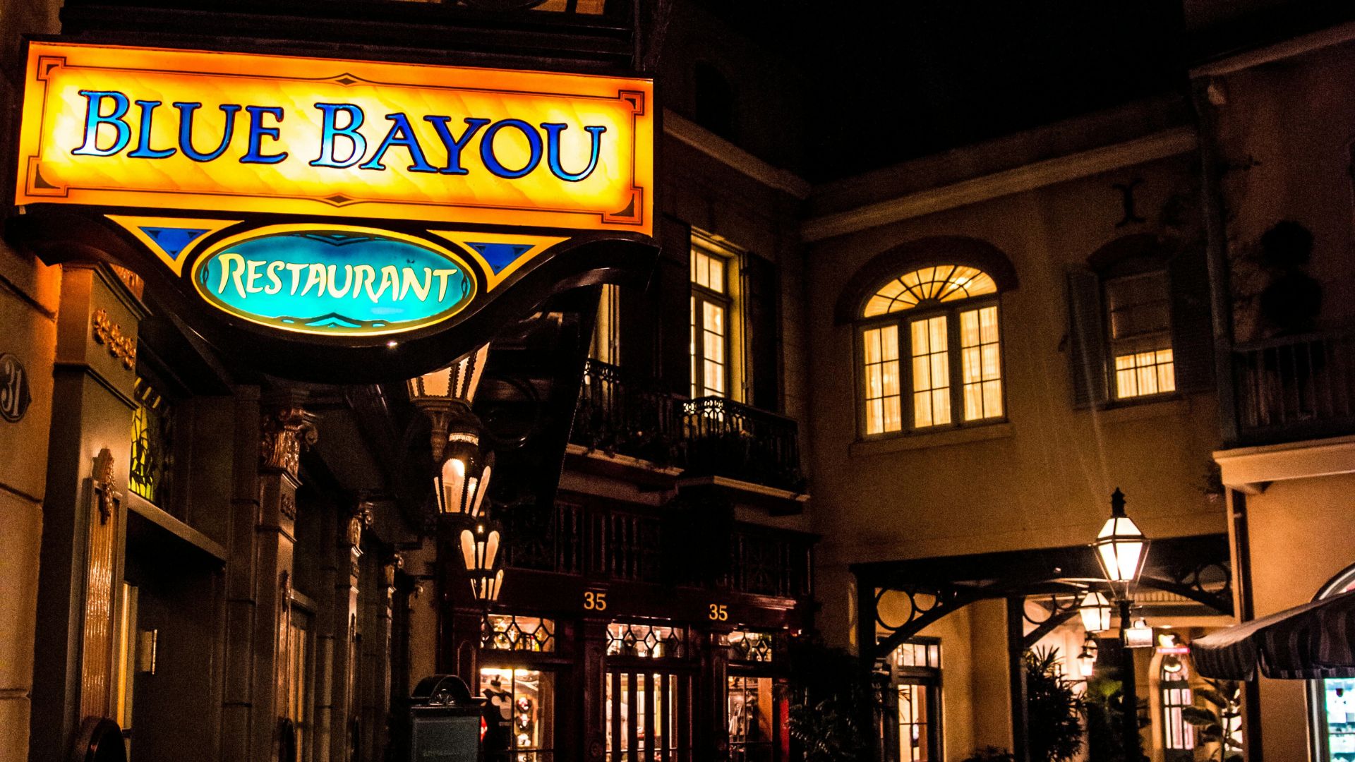 Blue Bayou Restaurant at Disneyland Park in Anaheim, California, illuminated at night, showcasing its iconic New Orleans Square ambiance and glowing sign.