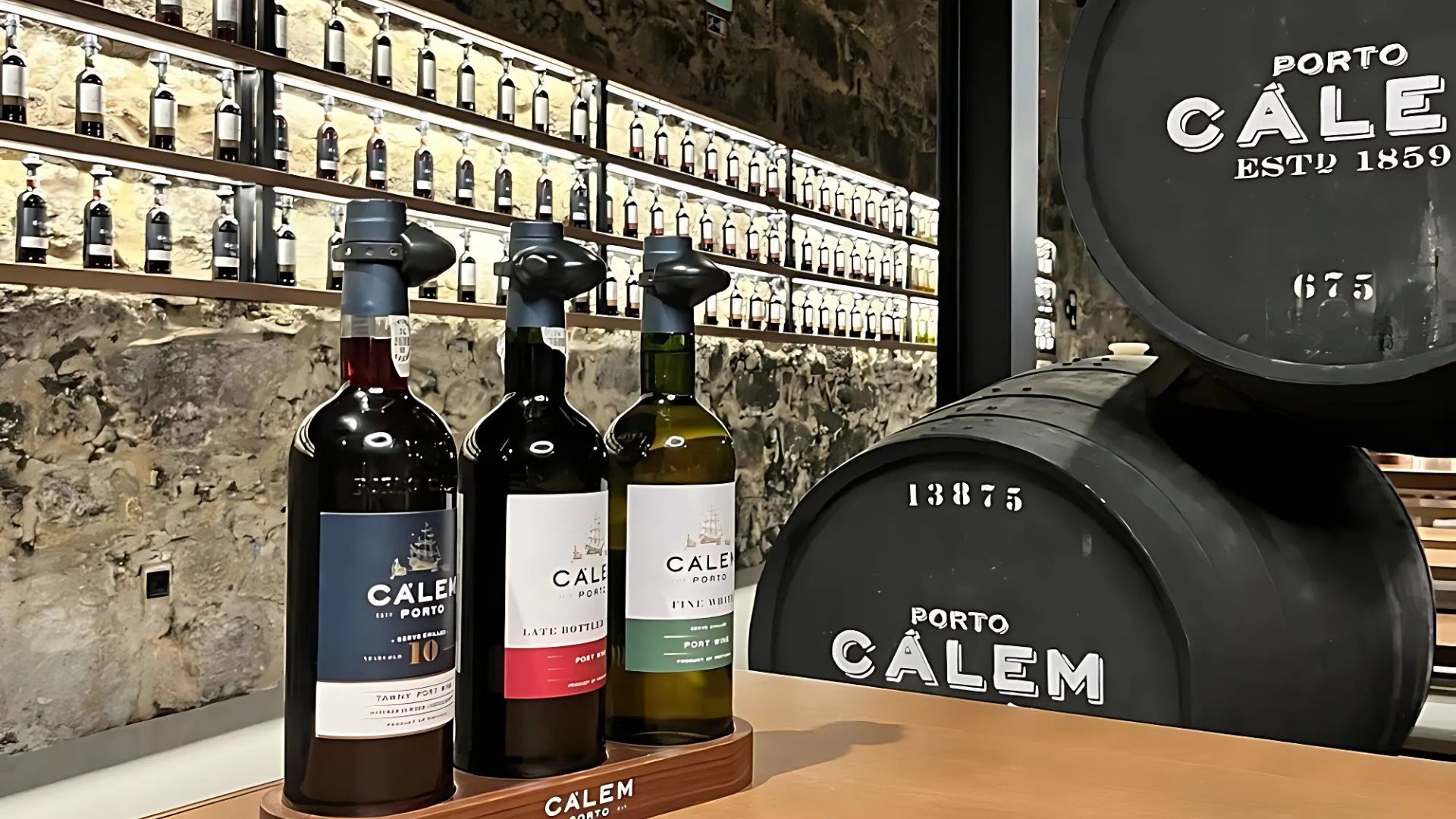 Three bottles of wine and a barrel at Cálem in Vila Nova de Gaia, Northern Portugal..