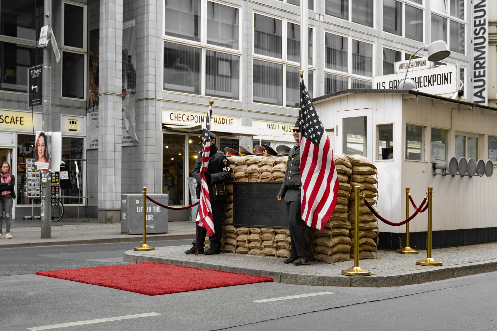 Checkpoint Charlie street scene with flags and museum in background