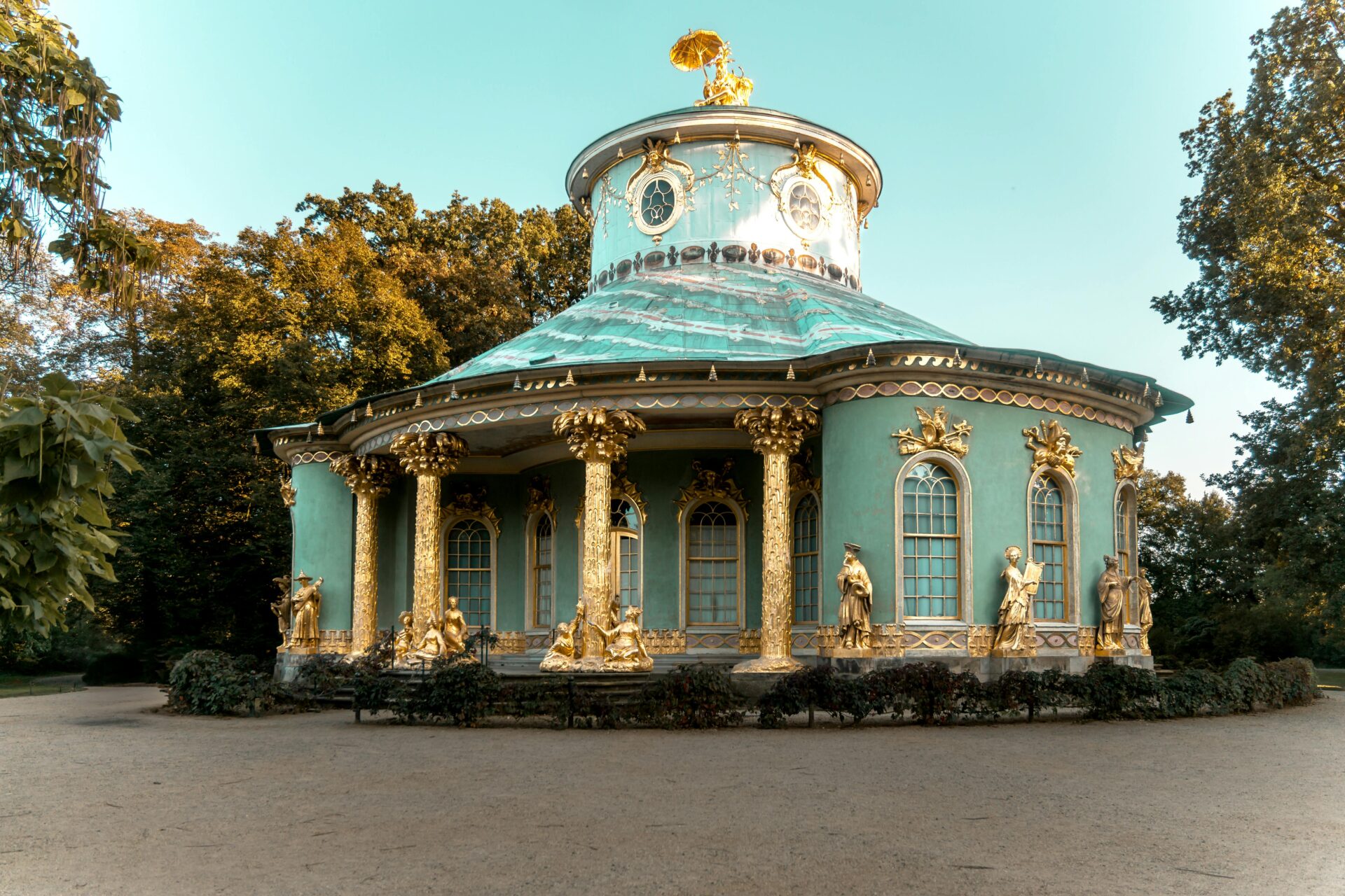 Chinese House pavilion in Sanssouci Park with gilded columns, domed roof, and life-size golden statues