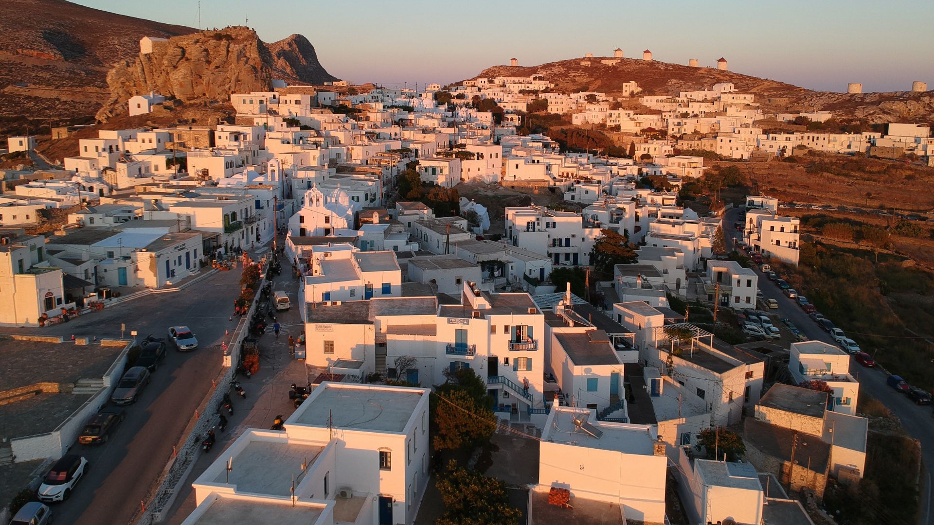 Aerial view of Chora village in Amorgos, Greece, featuring white buildings on a hillside.