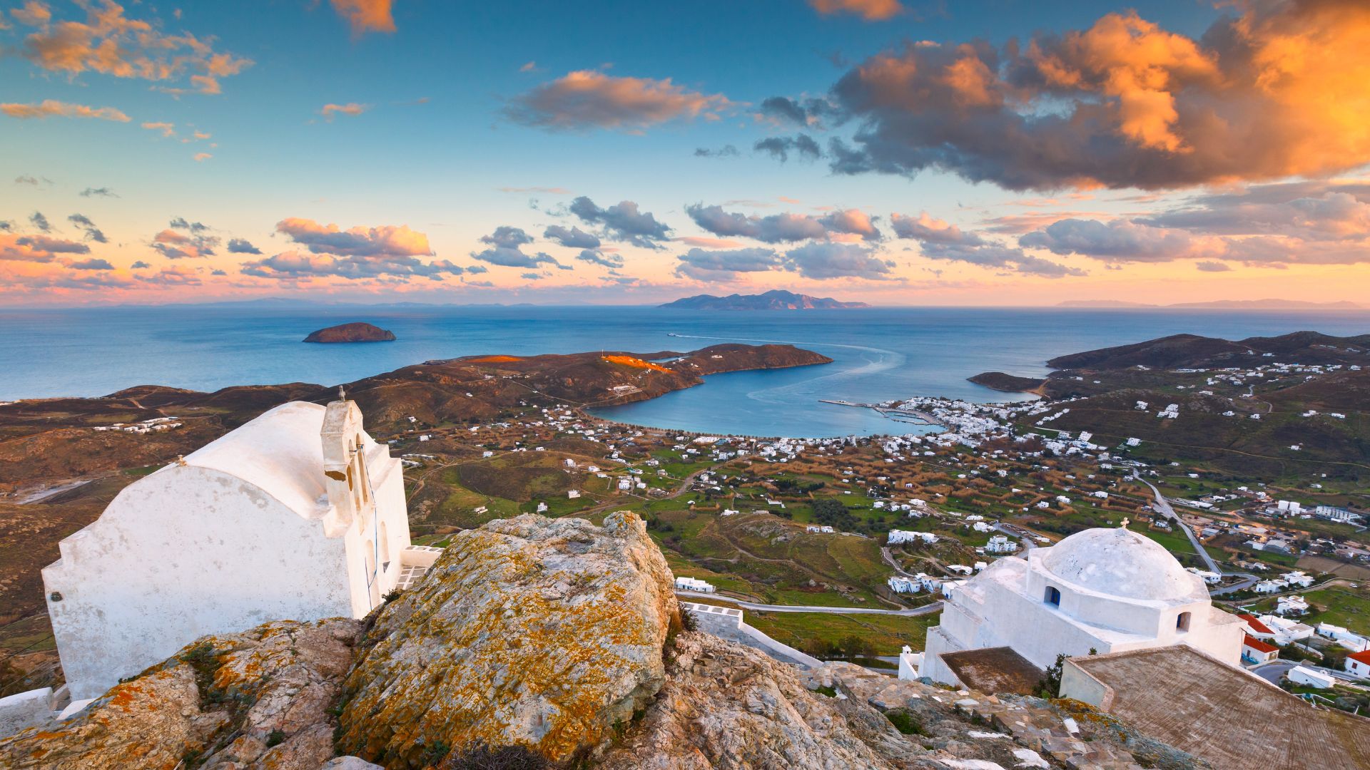 Panoramic view of Chora, Serifos, with whitewashed churches and Aegean Sea backdrop.