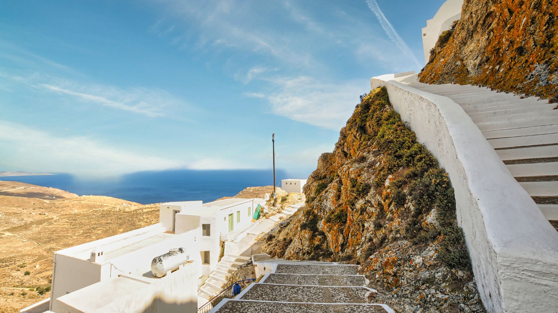 Stone stairs going to a hill in Chora Village in Serifos, Greece with white buildings. 