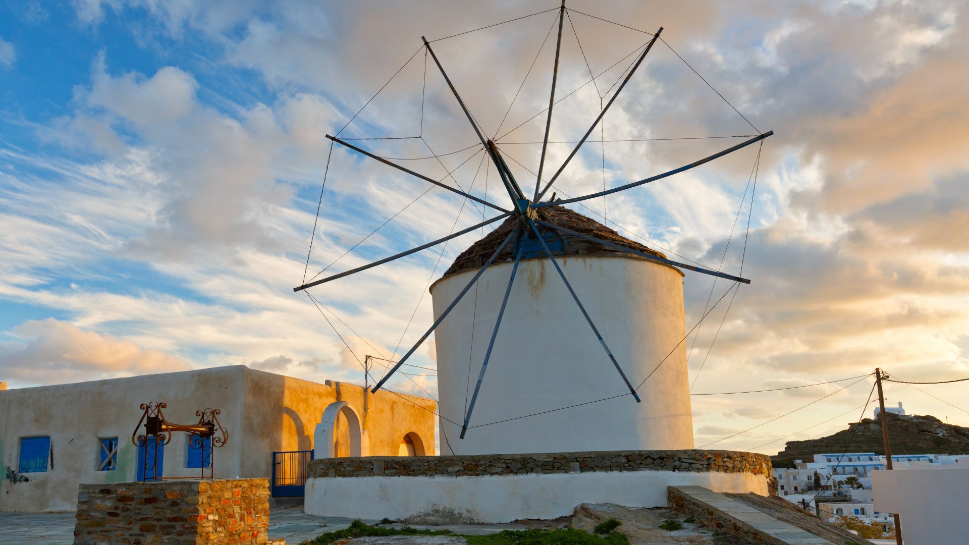 Sunset view of Chora village and a traditional windmill in Ios, Greece.