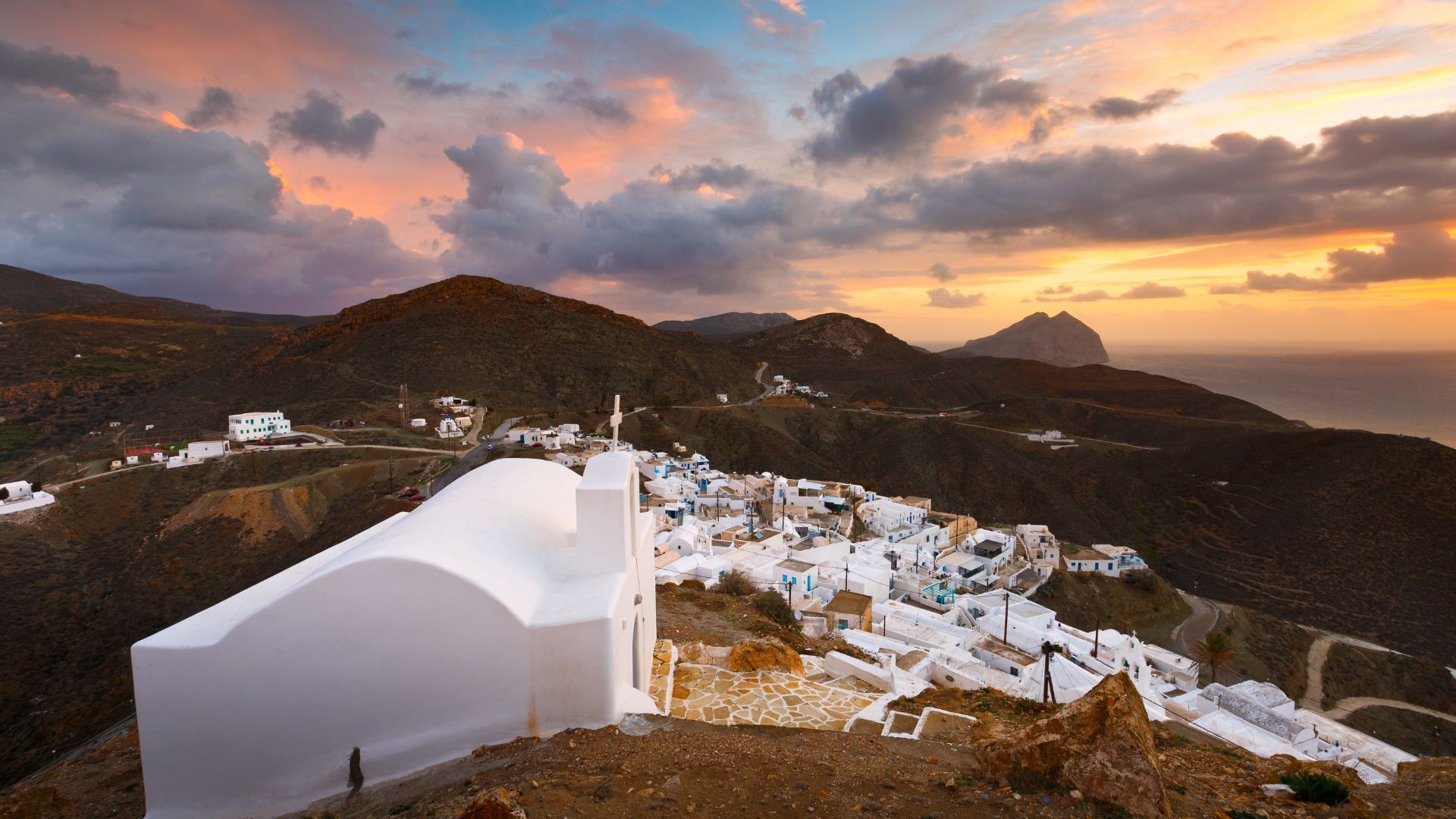 Sunset panorama of Chora village and a white church on Anafi Island, Greece.