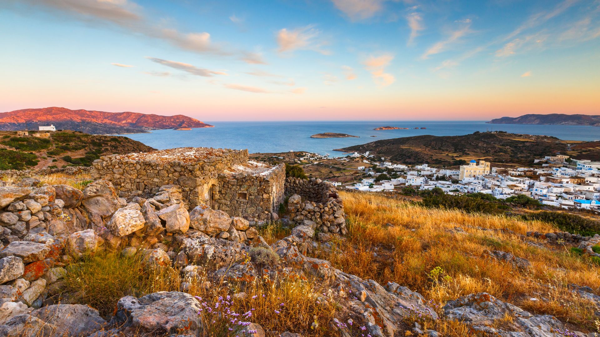 Kimolos island, Greece: picturesque Chora village with traditional Cycladic architecture and stunning Aegean Sea views at sunset.