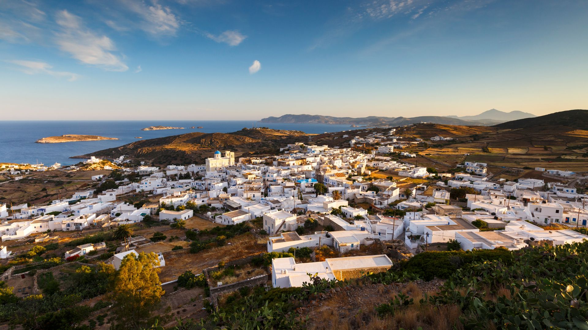 Picturesque Chora village with traditional Cycladic architecture and stunning Aegean Sea views at sunset.