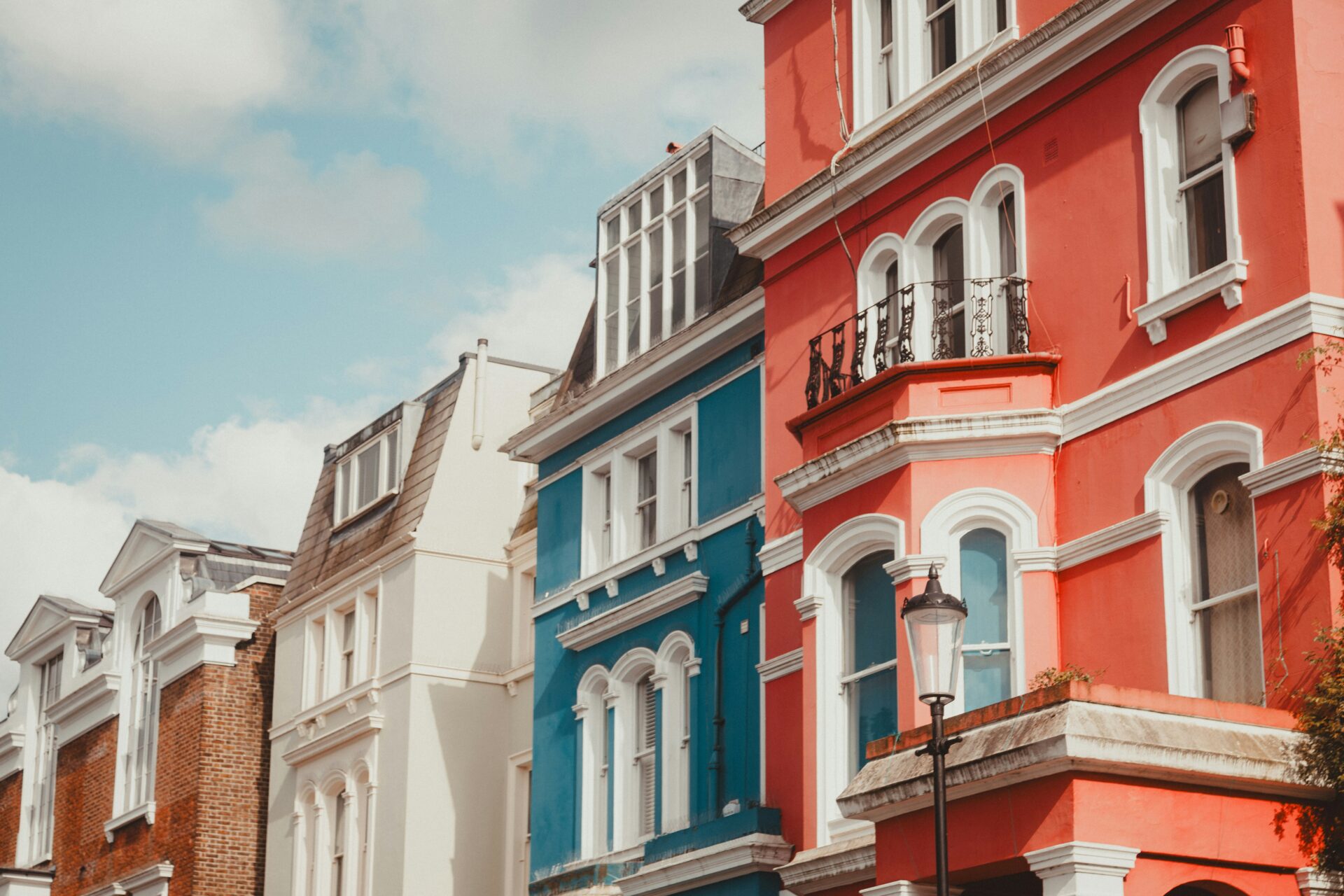 Row of colorful houses lining a street in Notting Hill, London.