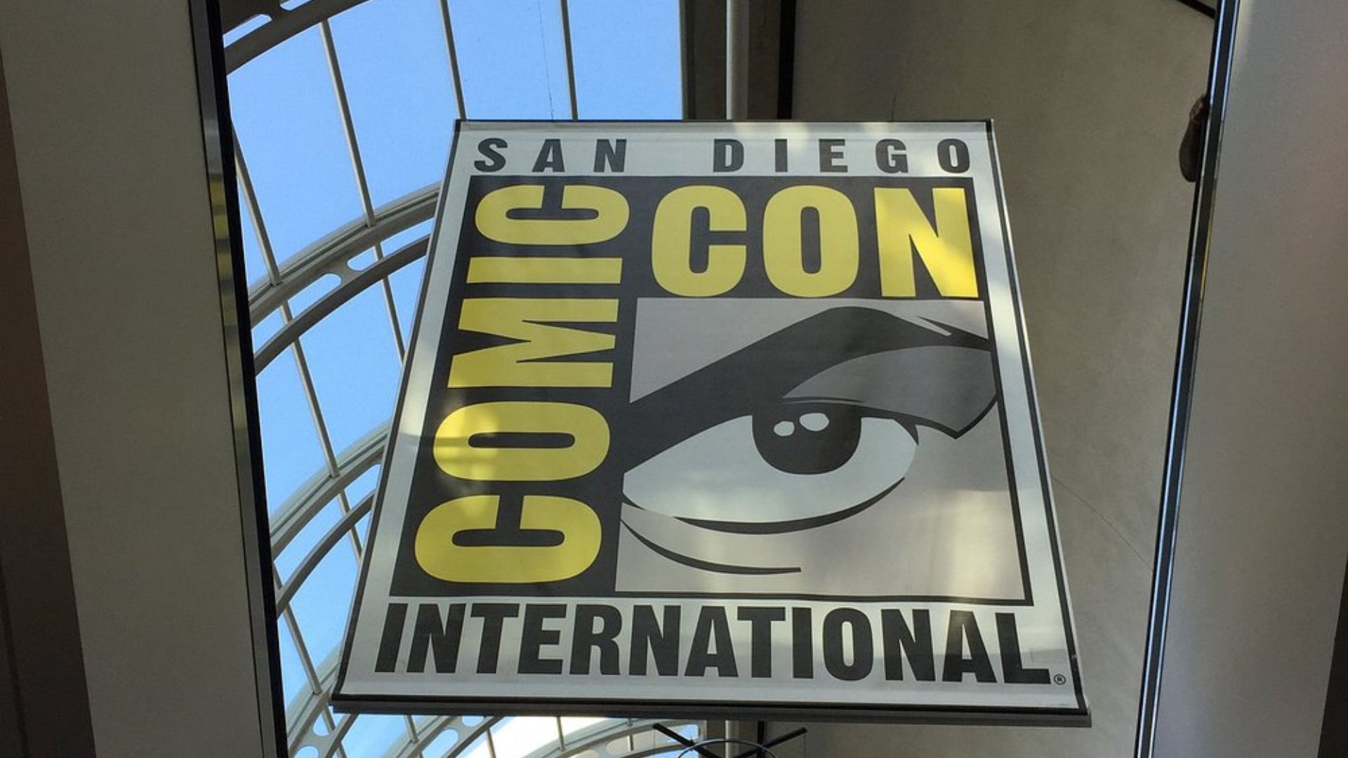  A banner for San Diego Comic-Con International hangs in an arched hallway, with sunlight visible through a skylight.