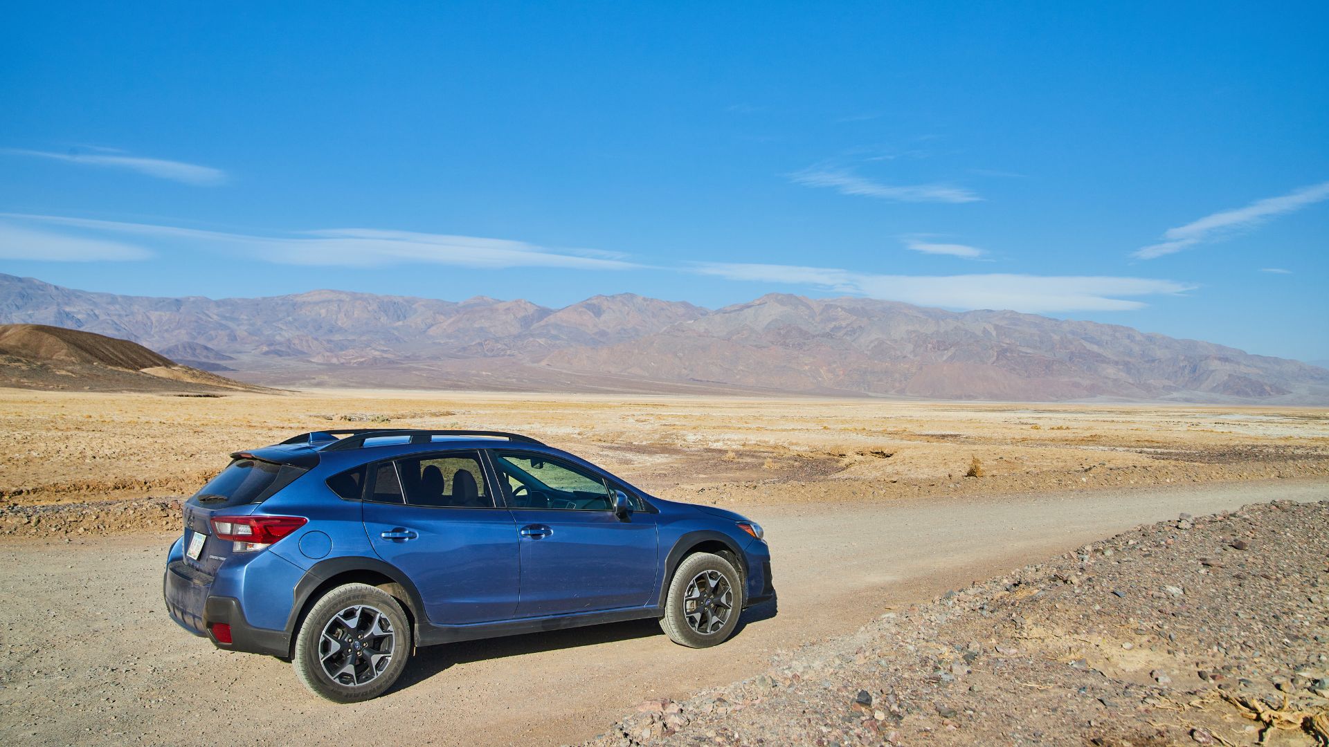 A blue car driving in desert