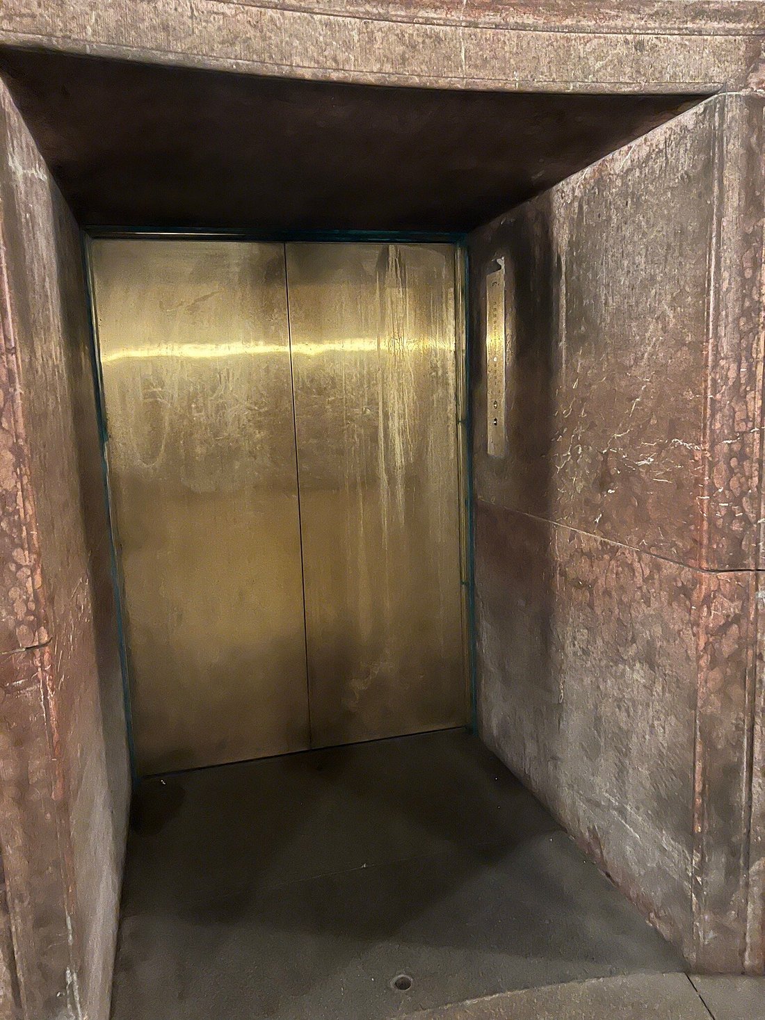Polished brass elevator door inside the stone tunnel at Eagle’s Nest