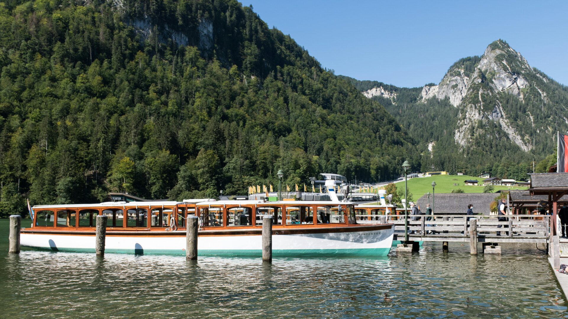 Electric boat docked at the pier on the emerald-green waters of Königssee