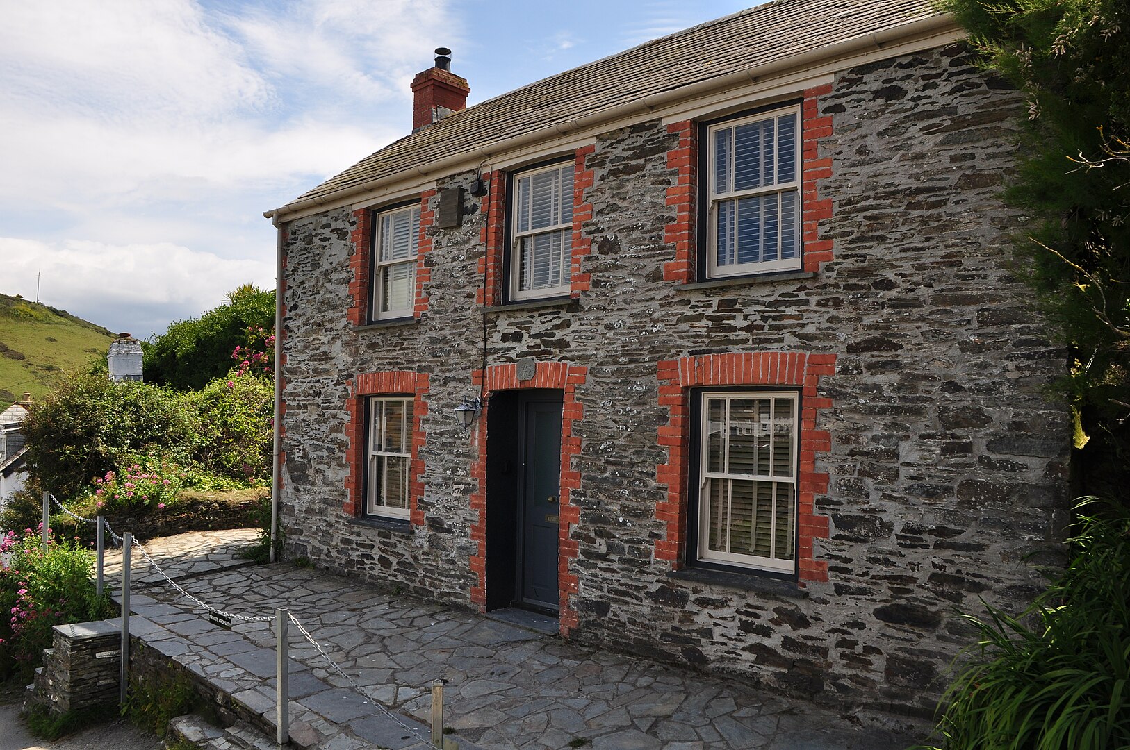 Fern Cottage in Port Isaac, featured as Doc Martin’s home in the TV series, with its traditional stone exterior and garden setting.