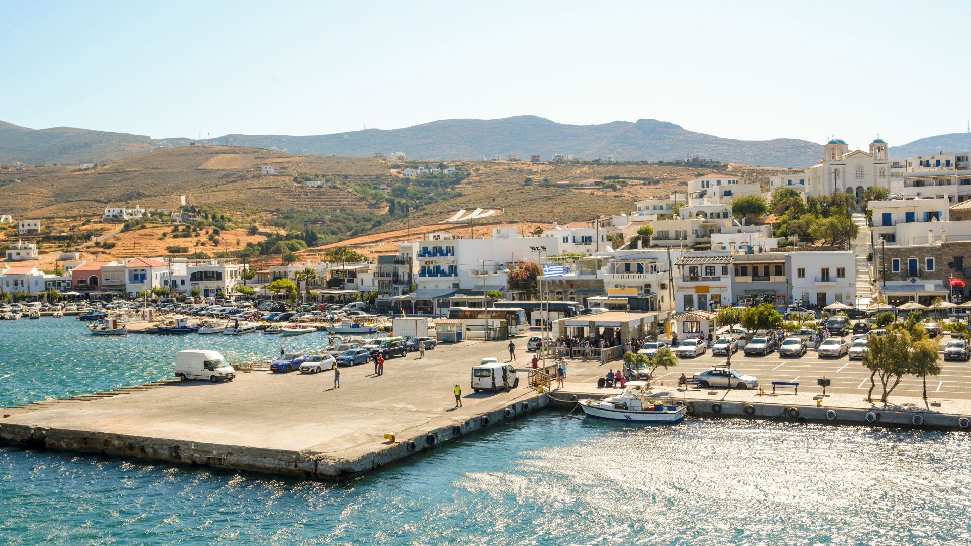 View of Gavrio port in Andros, Greece, with a harbor and white buildings.
