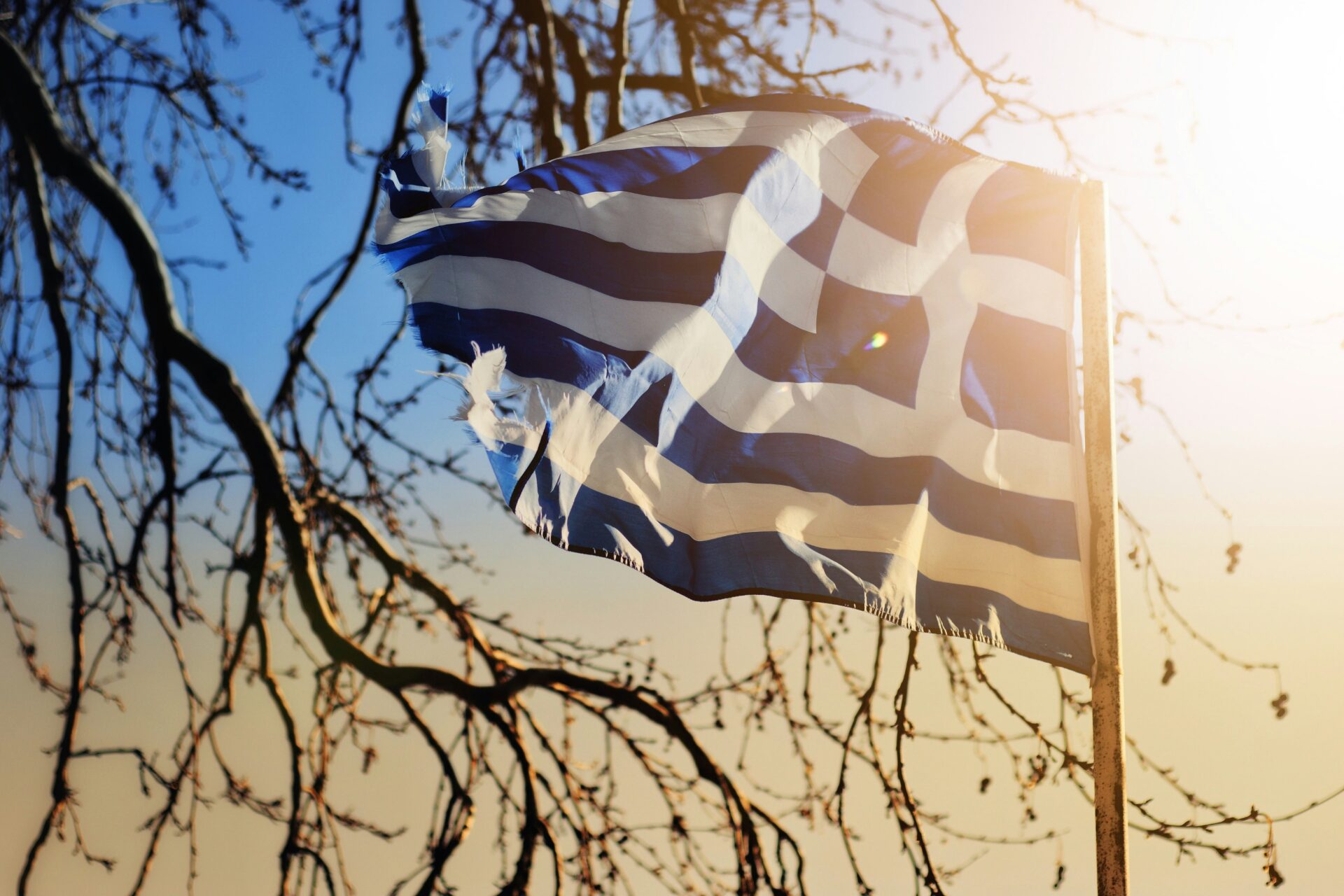 Greek flag with a sunlight behind