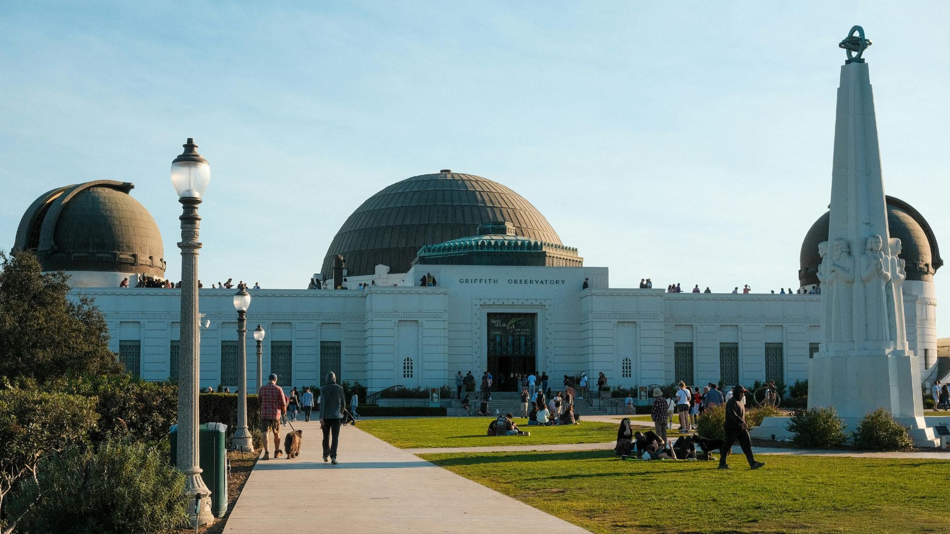 View of Griffith Observatory, a landmark in Los Angeles, California, showcasing its distinctive white building with domes, surrounding green spaces.