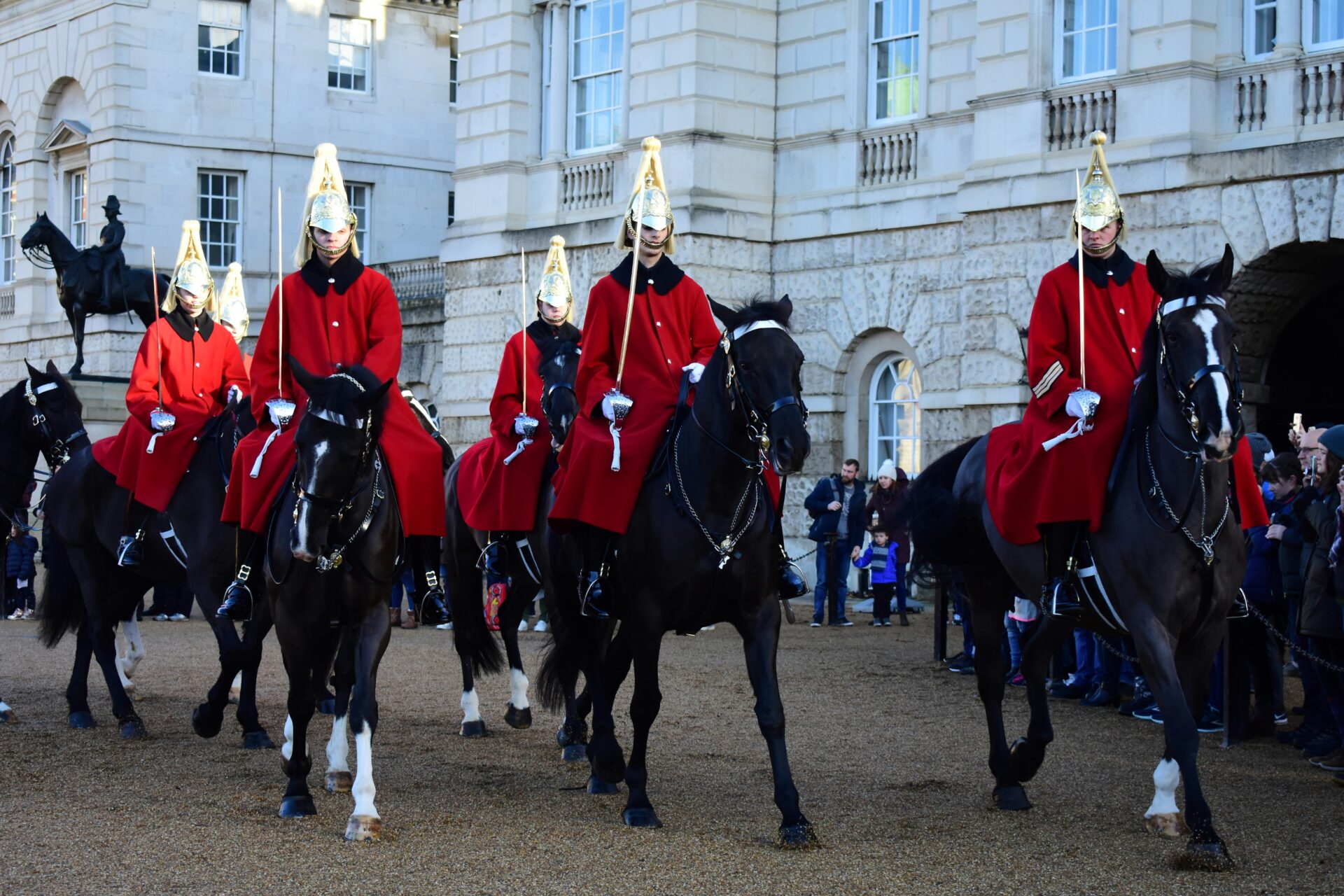 Guards on horseback in red uniforms outside Buckingham Palace during the Changing of the Guard.