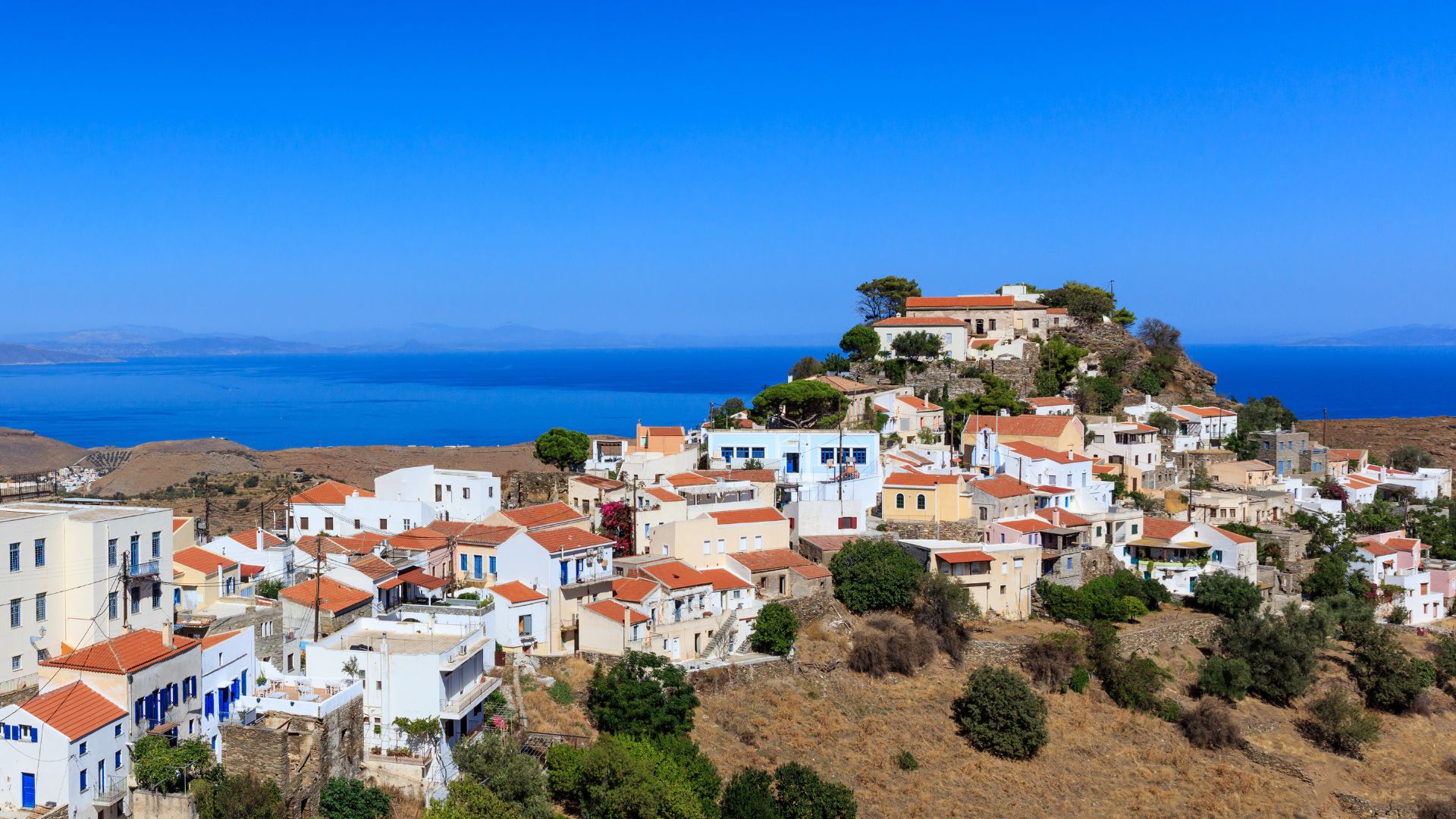 Picturesque village of Ioulis on Kea Island, Greece, with its traditional white houses and red roofs overlooking the Aegean Sea.