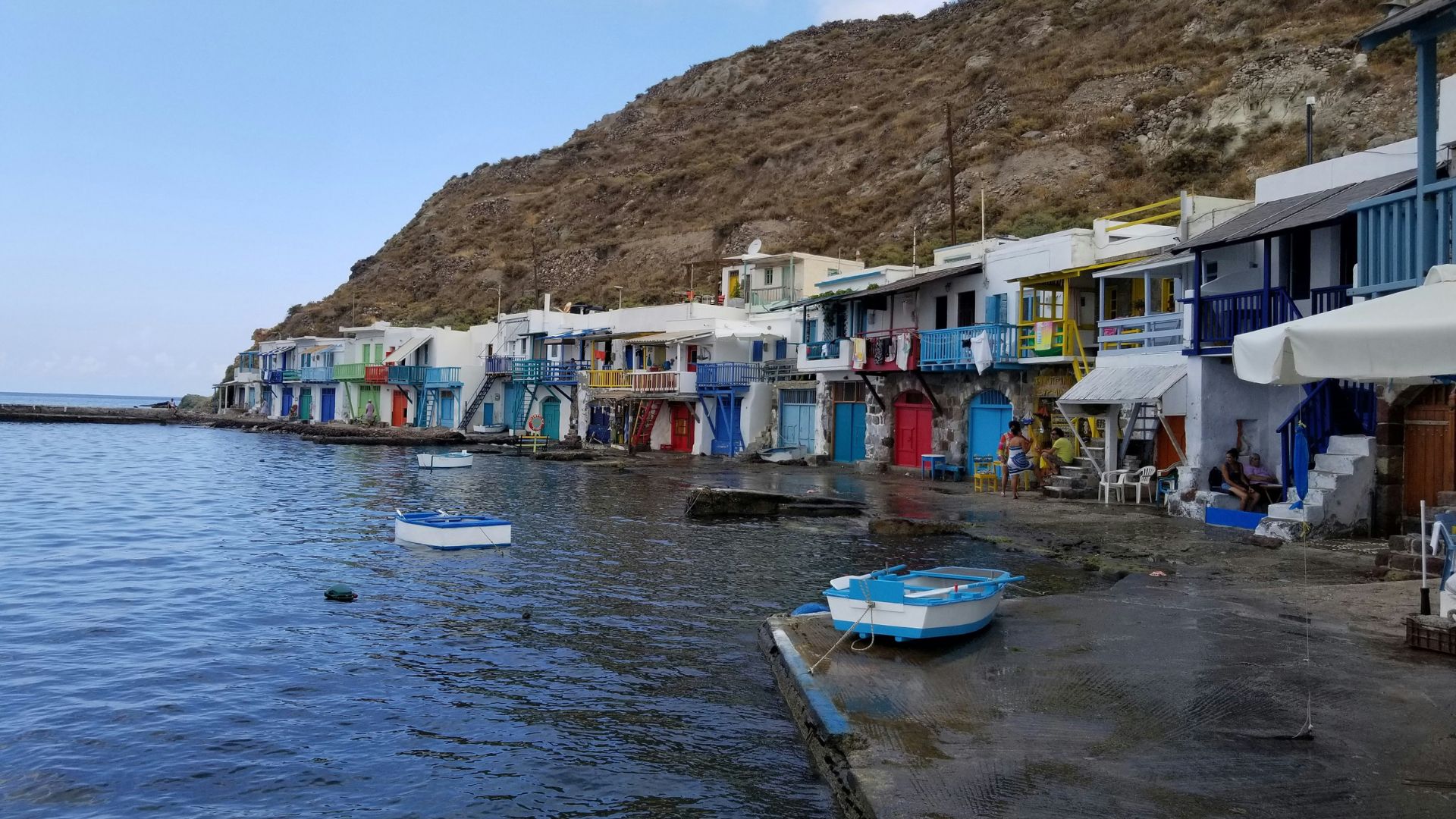 Colorful fishing houses line the waterfront in Klima, a picturesque village on the Greek island of Milos.