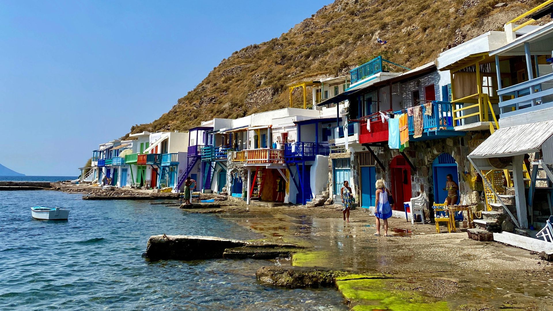 Colorful boathouses line the shore in Klima, a charming fishing village on Milos Island, Greece