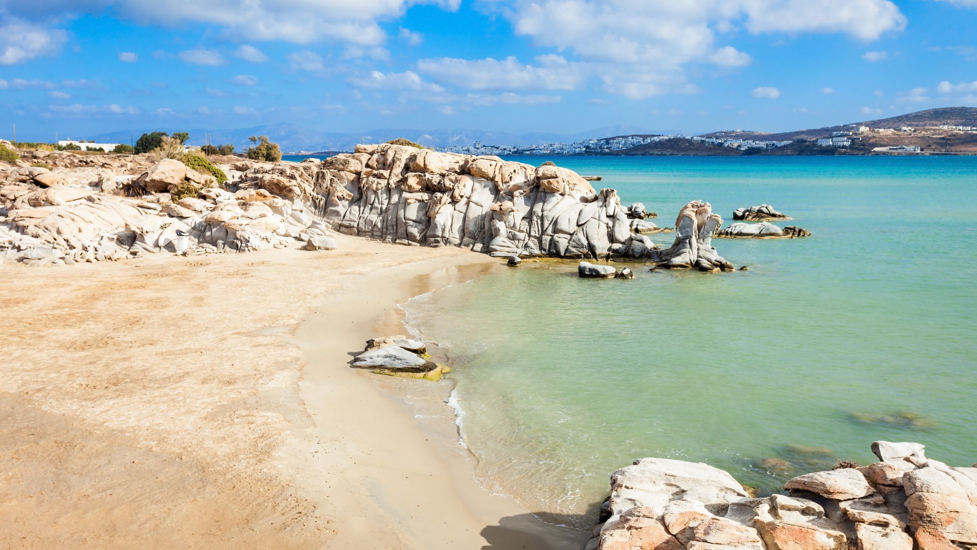Kolymbithres Beach in Paros, Greece, featuring unique rock formations, whiite sand, and clear blue water.