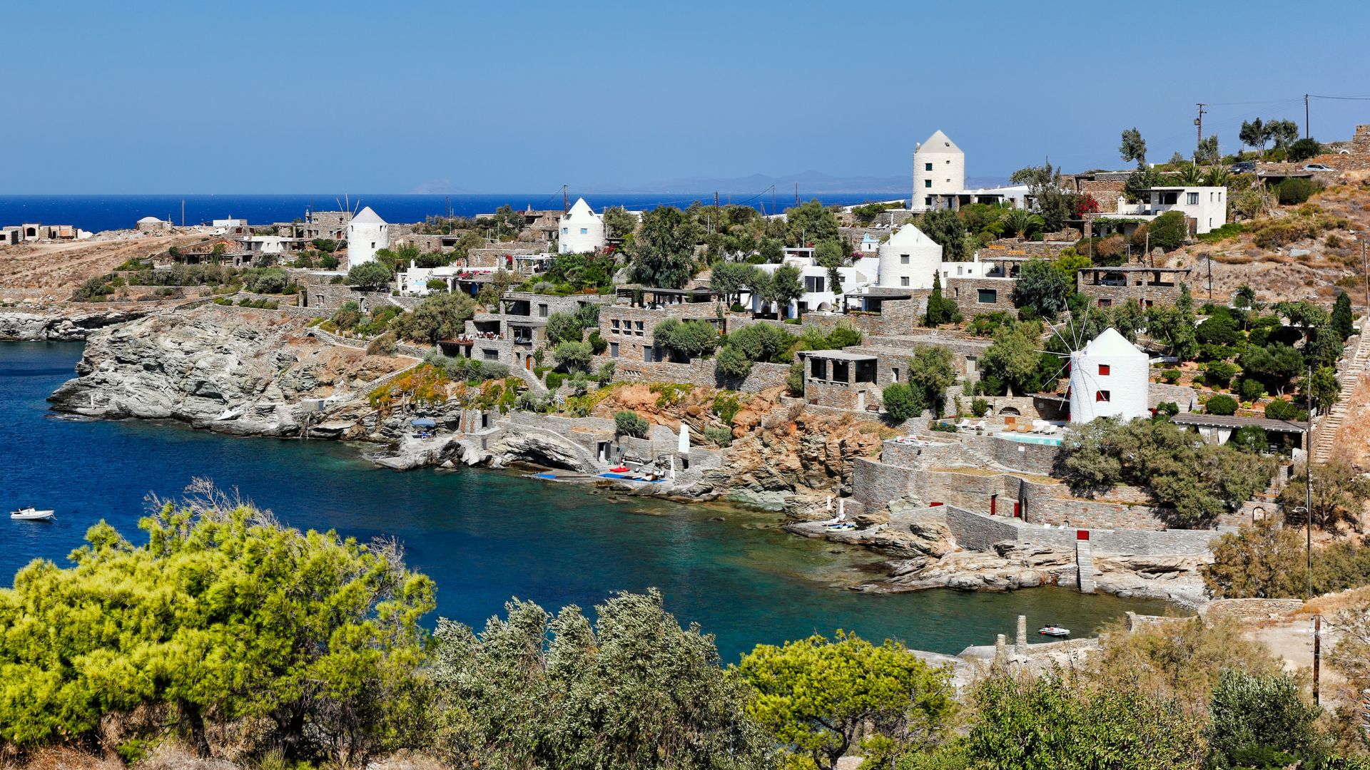 Picturesque Koundouros Beach in Kea, Greece, with its crystal-clear waters and traditional white buildings.