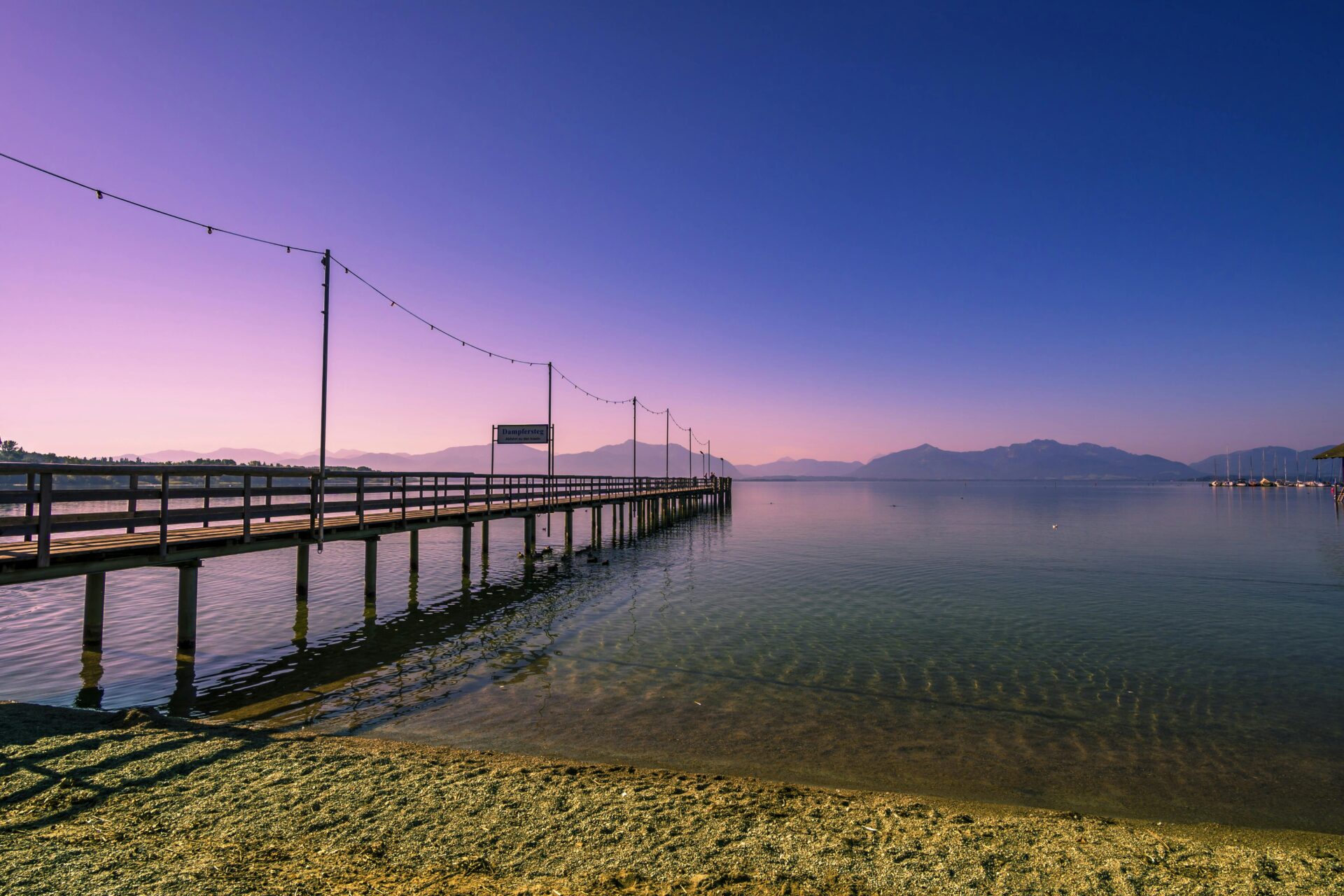 Scenic Chiemsee shoreline with reflections of clouds on the lake’s surface