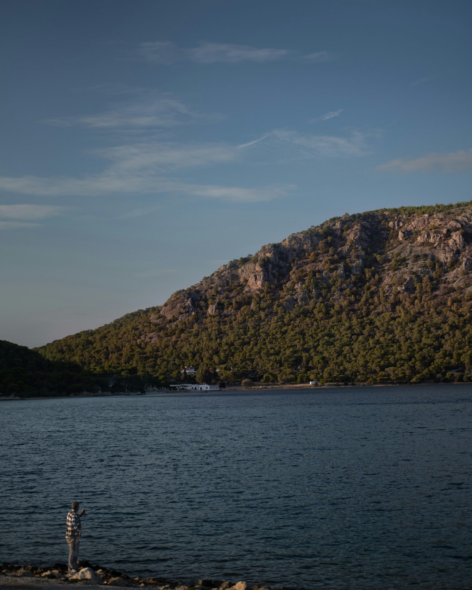 Lake Vouliagmeni - Vouliagmeni, Greece - a lake with a mountain range backdrop