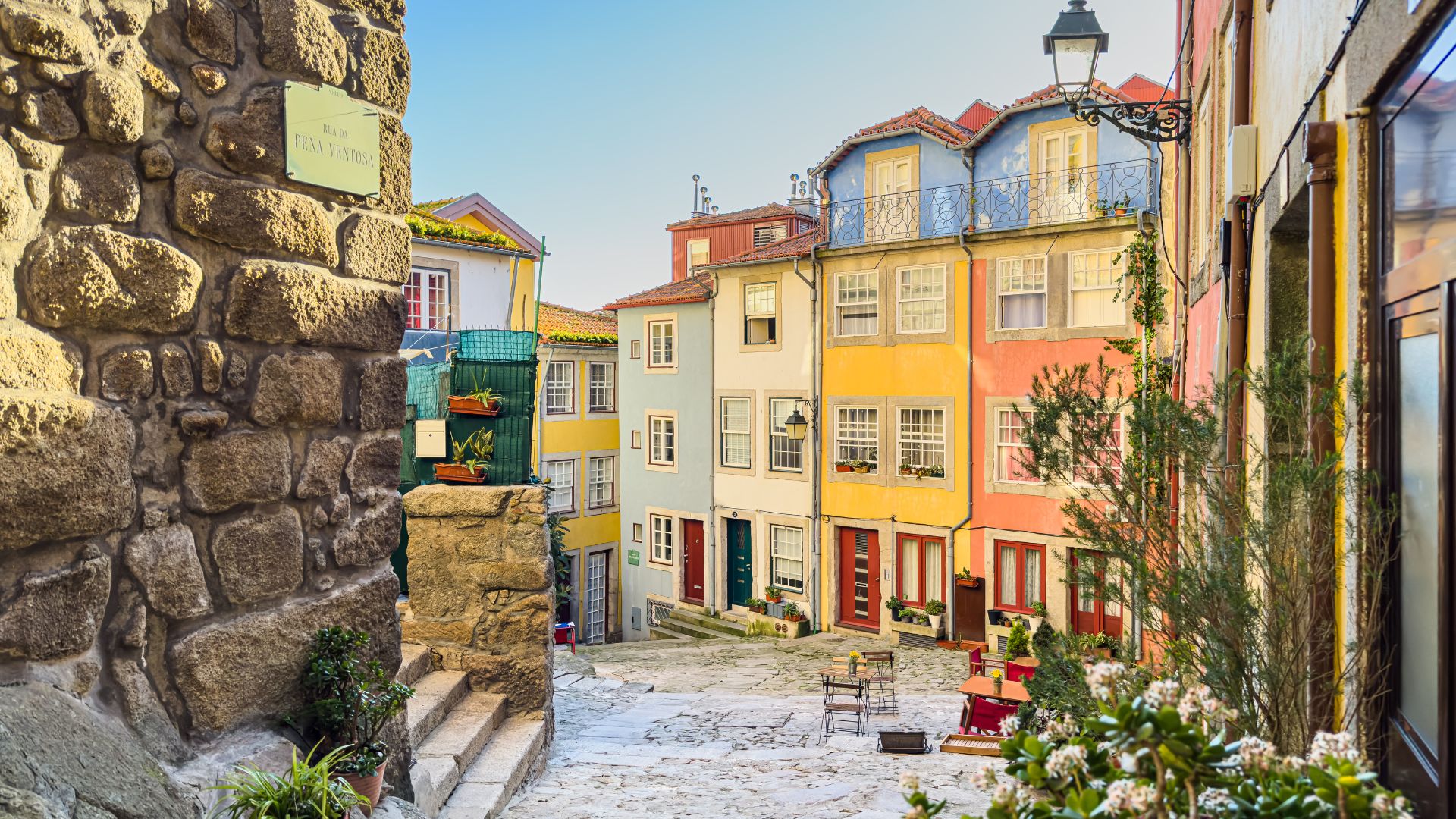 A vibrant view of Largo da Pena Ventosa in Porto, Portugal, showcasing colorful buildings and cobblestone streets.