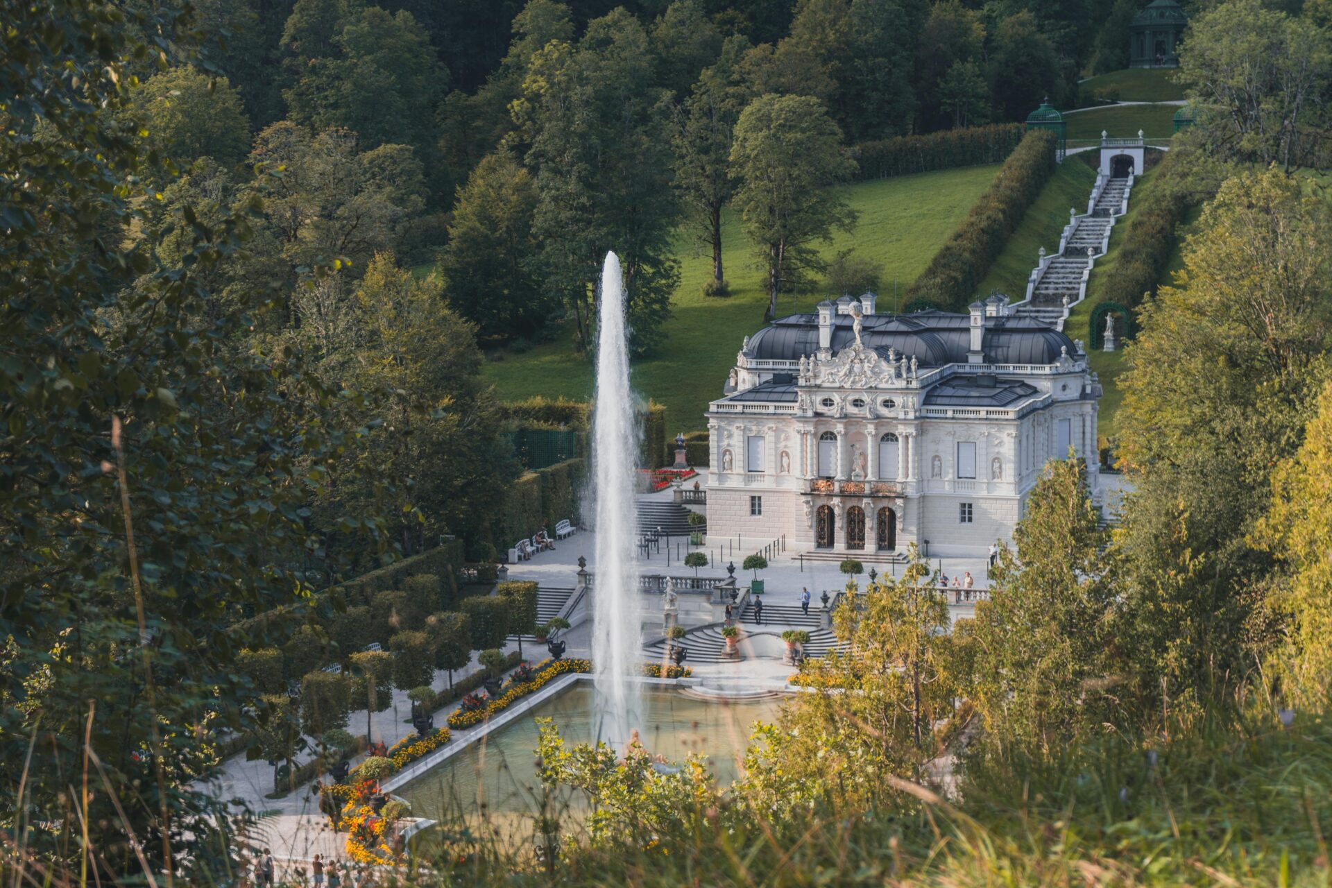 Linderhof Palace facade with manicured gardens and water fountain in front