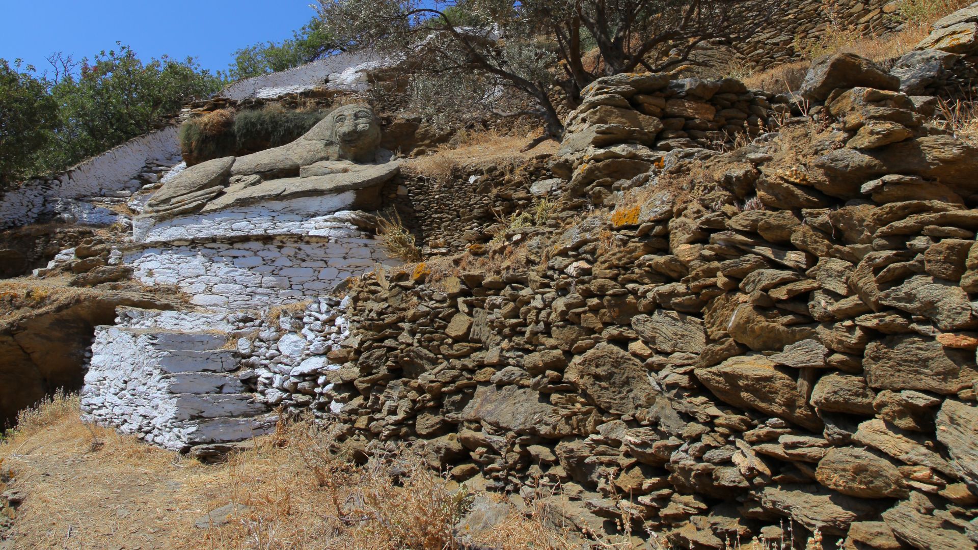 Ancient stone lion sculpture, Lion of Kea, on a Greek island, symbolizing protection and history.