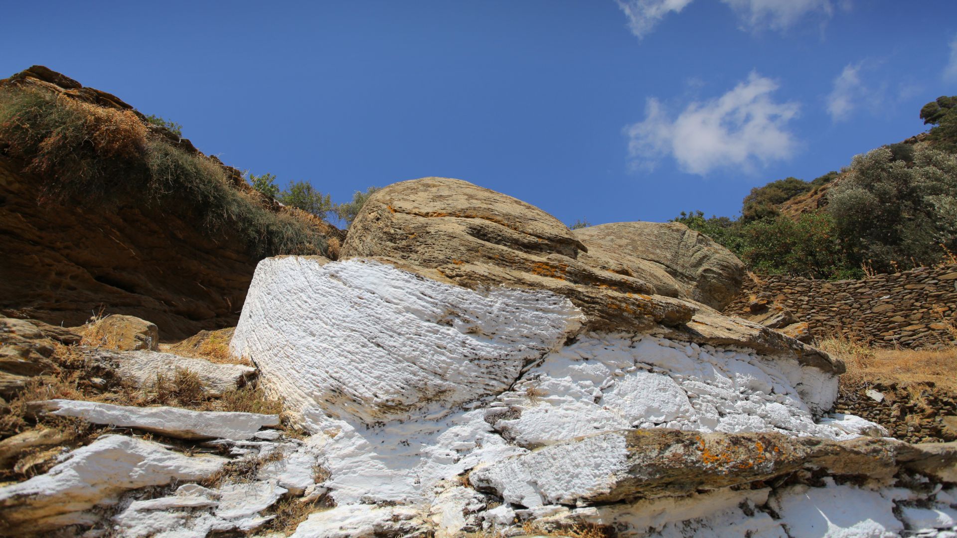 Ancient stone lion sculpture, Lion of Kea, on a Greek island, symbolizing protection and history.