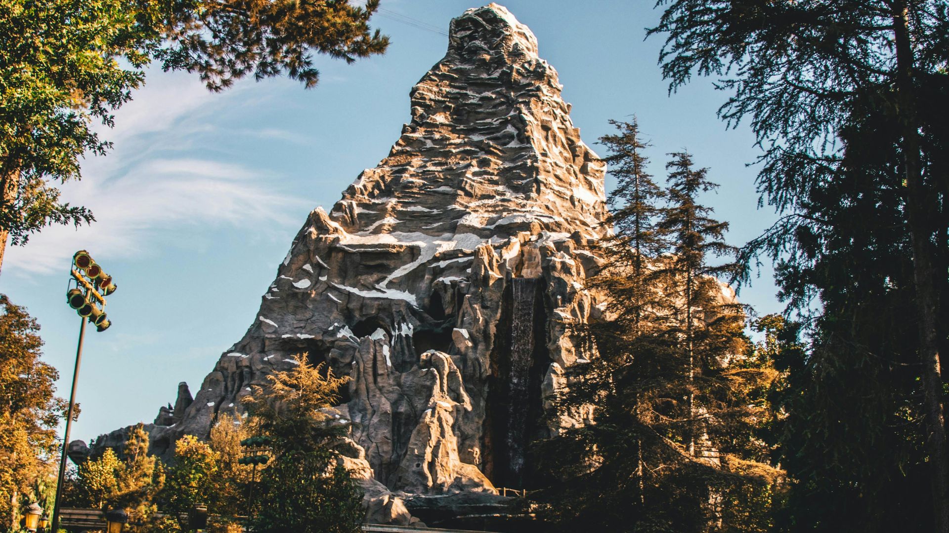 Matterhorn Bobsleds mountain at Disneyland Park Anaheim California with lush green trees and clear sky