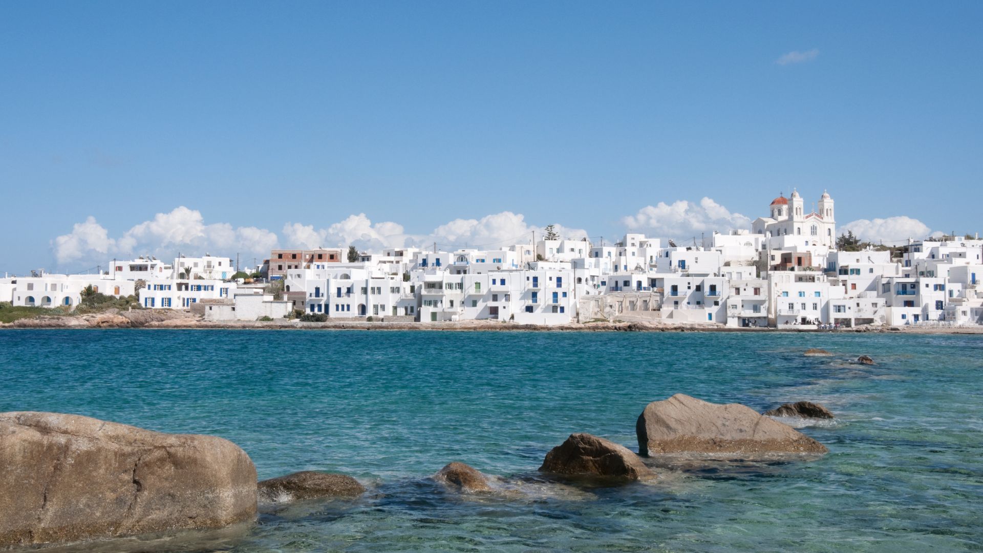Scenic view of white building and blue waters of Naoussa Village in Paros, Greece