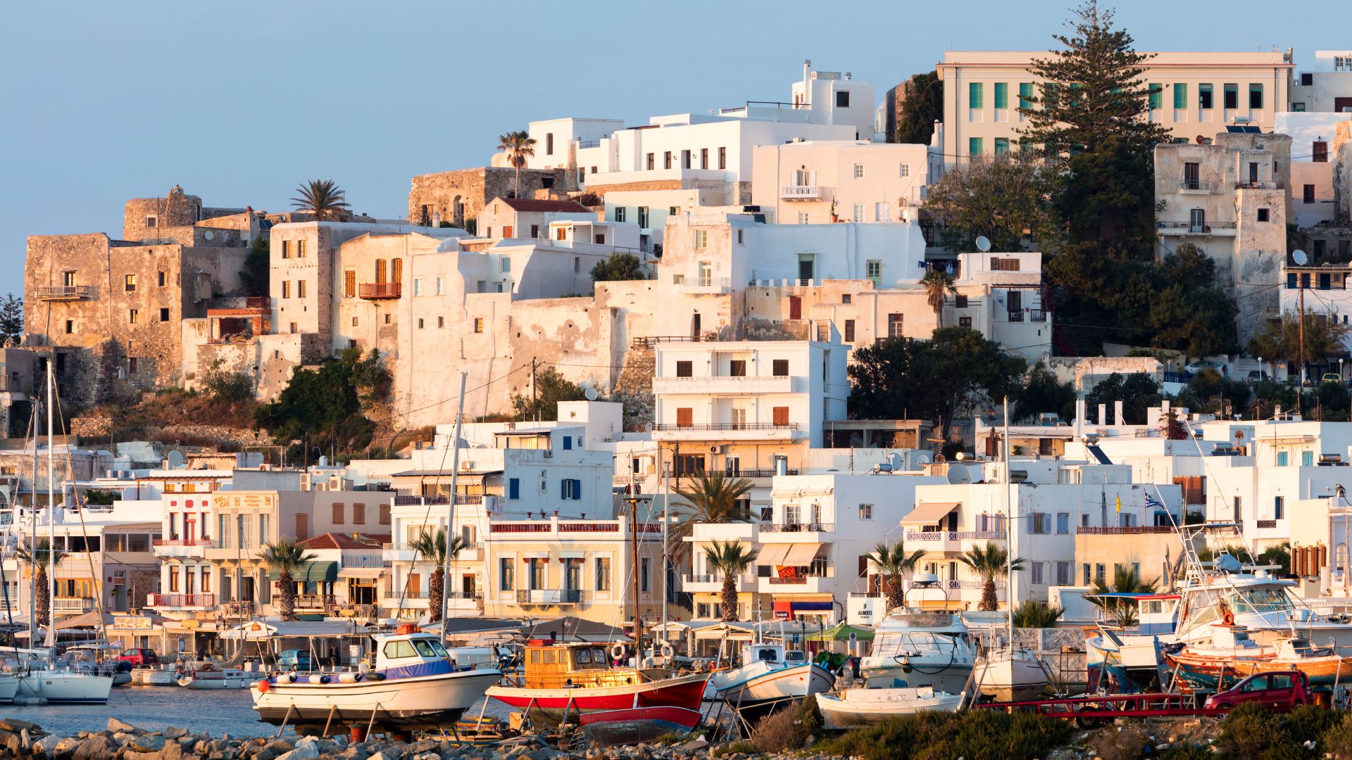 A coastal town in Naxos, Greece, with white buildings and a harbor full of boats.