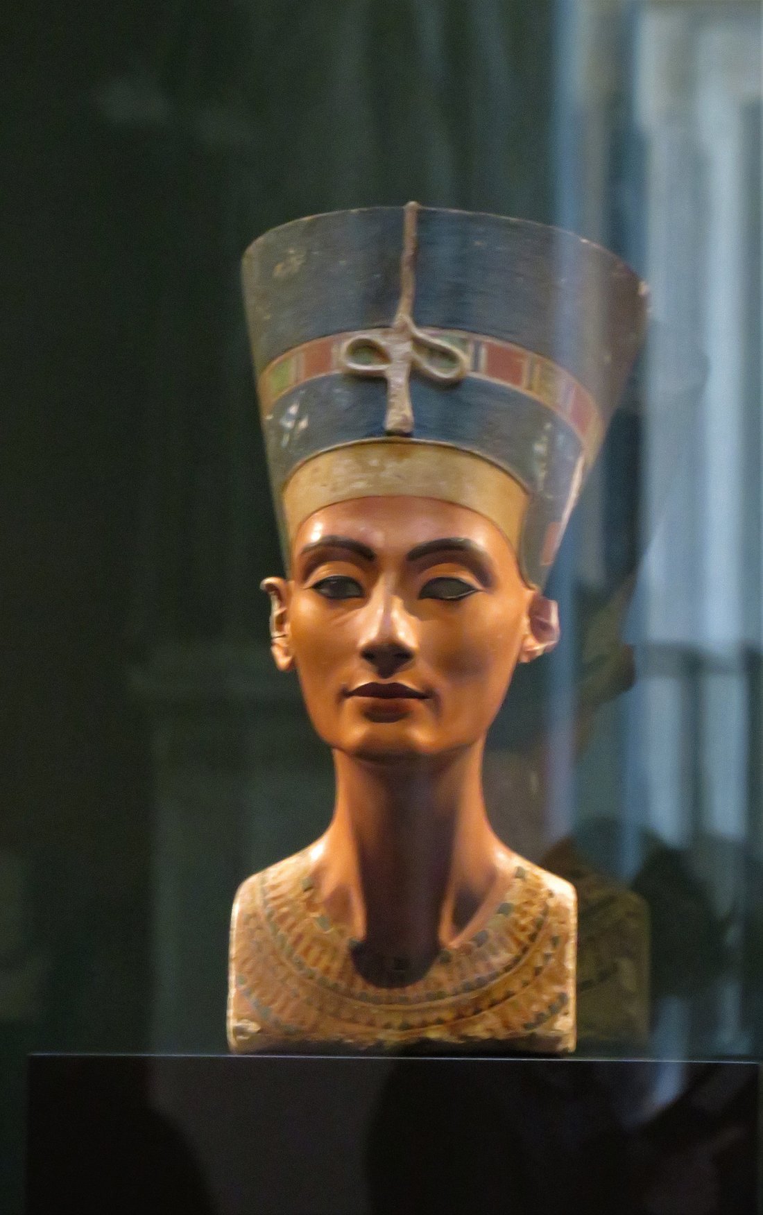 The iconic Bust of Queen Nefertiti displayed in a glass case at the Neues Museum in Berlin