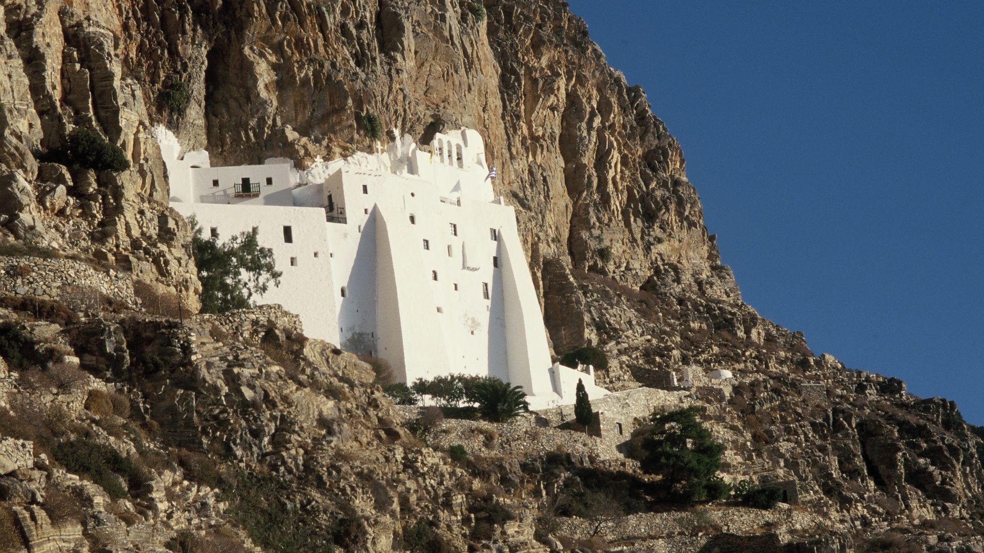 Panagia Hozoviotissa Monastery built into a cliffside overlooking the Aegean Sea.