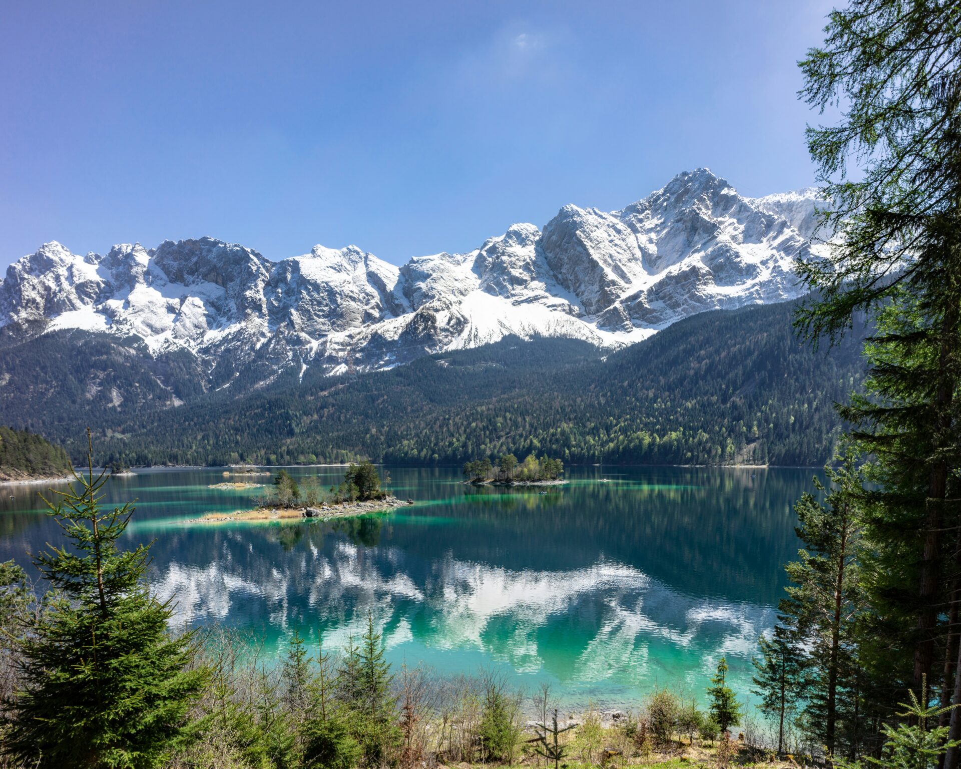Peaceful Eibsee Lake surrounded by forest and framed by the dramatic Zugspitze mountain