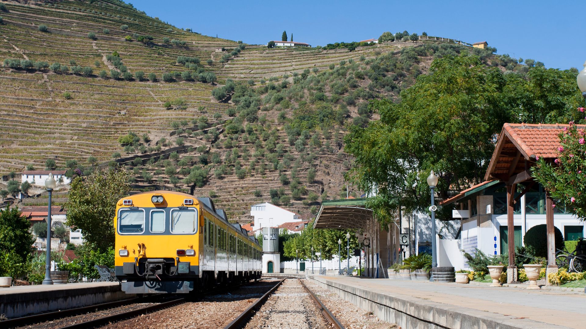 A yellow train at Pinhão Railway Station in Pinhão Village, Northern Portugal.