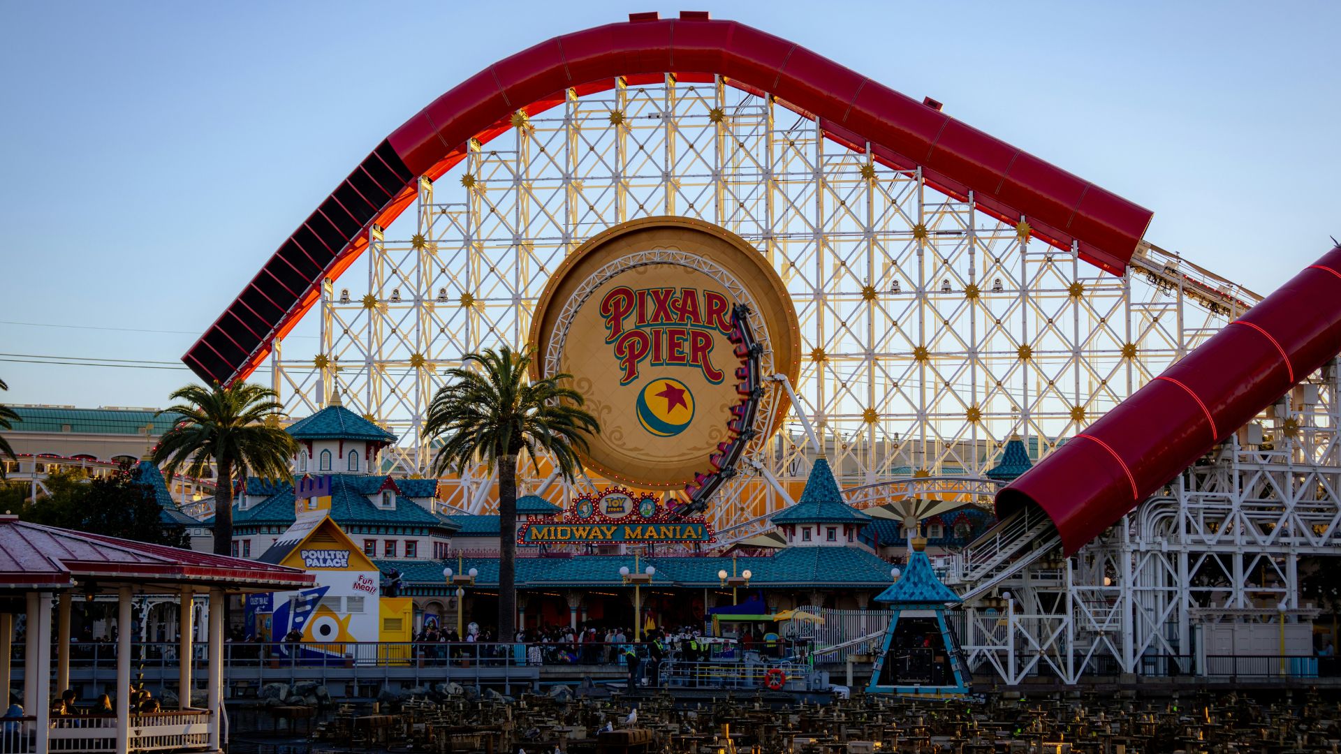Vibrant Pixar Pier at Disney California Adventure Park featuring the iconic Incredicoaster roller coaster loop and Pixar Pal-A-Round Ferris wheel in the background, perfect for travel, theme park, and family vacation keywords.