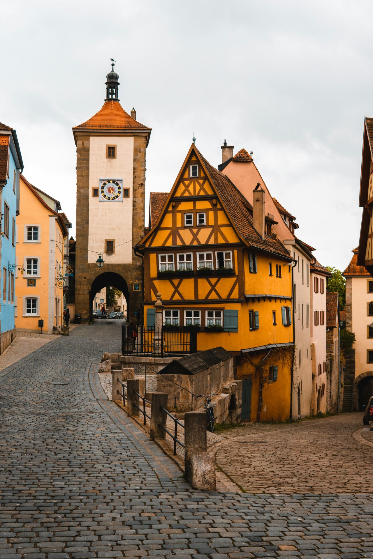 The Plönlein in Rothenburg ob der Tauber with a tilted half-timbered house between two cobbled streets and medieval towers