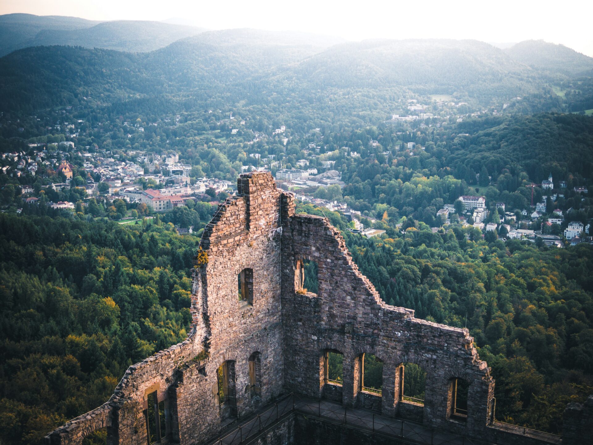 Ruins of an old castle illuminated by the low sun with the city of baden-Baden
