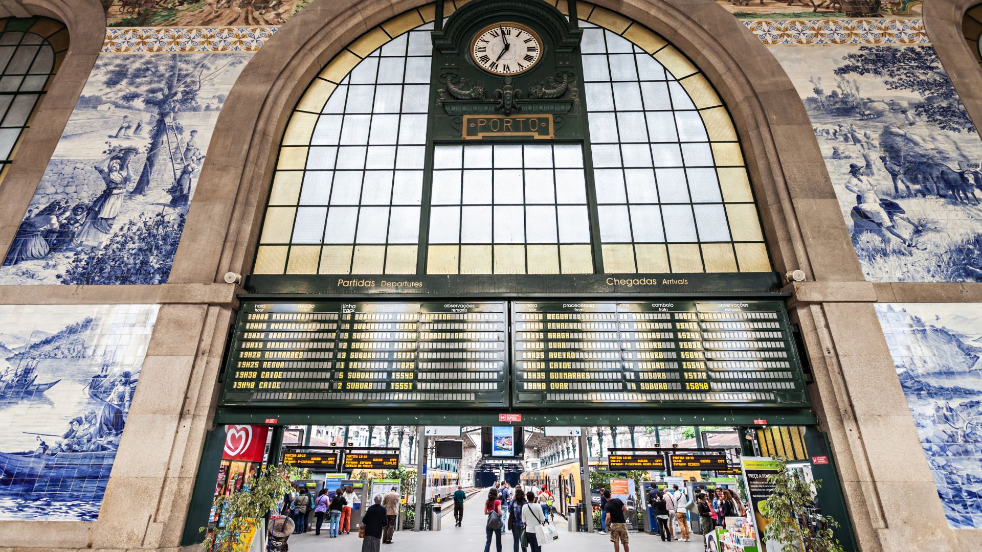 A view of the interior of the São Bento Railway Station in Porto, Portugal, showcasing the elaborate blue and white azulejo tile murals that cover the walls.