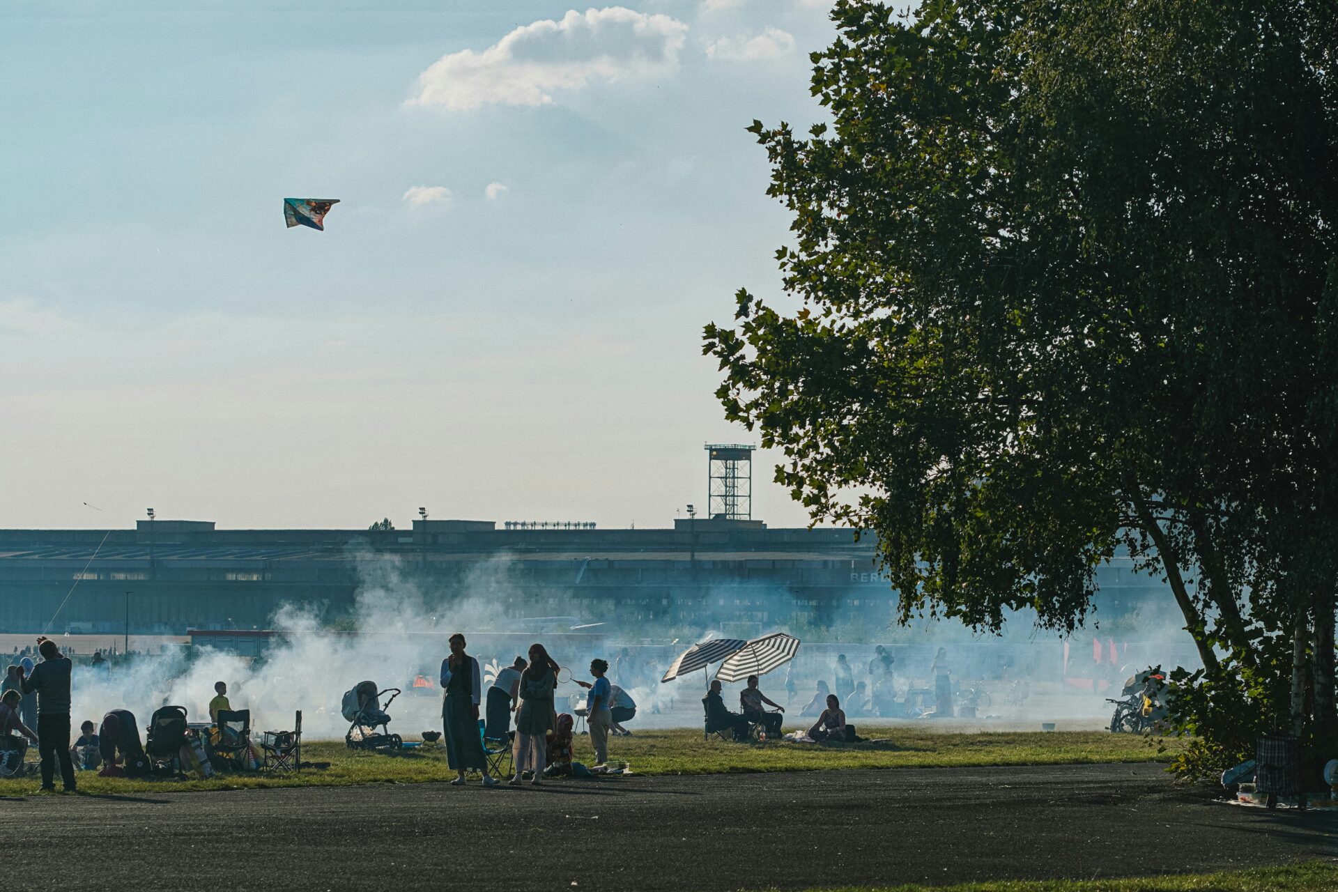 Groups of friends gathered for summer BBQs on the grass at Tempelhofer Feld