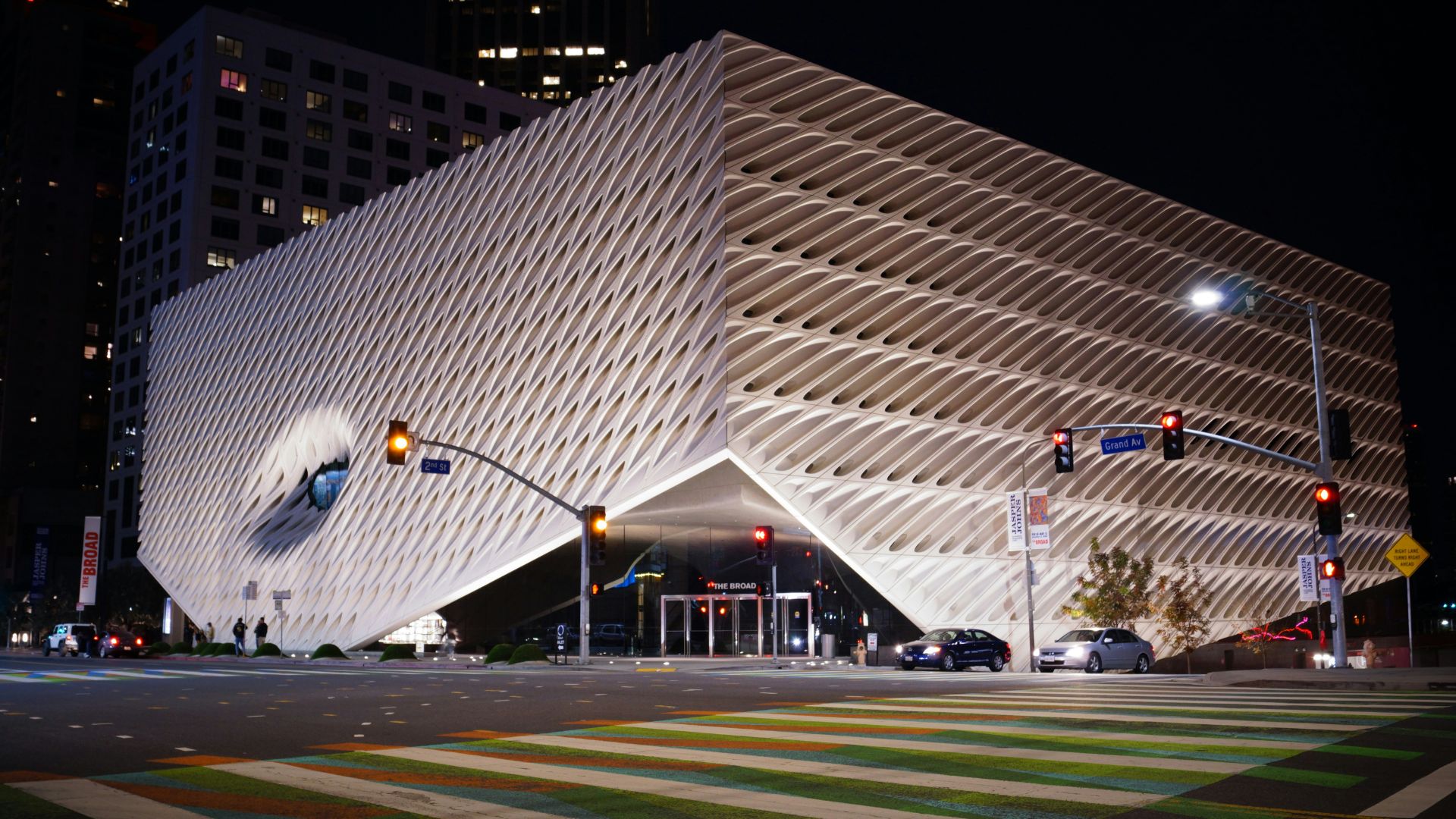The Broad Museum in Los Angeles at night, showcasing its distinctive honeycomb-like exterior facade and illuminated entrance on Grand Avenue, ideal for contemporary art and architecture enthusiasts. 