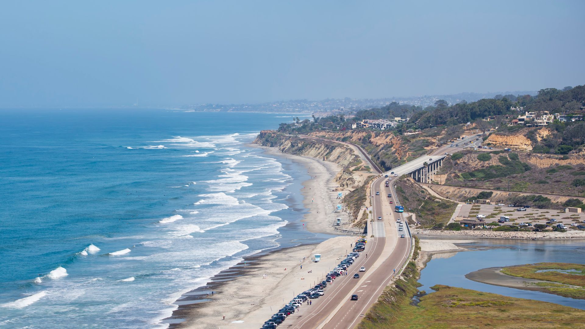 Aerial view of Torrey Pines State Beach along the Pacific Coast Highway in Southern California, showcasing the coastline, cliffs, and highway.