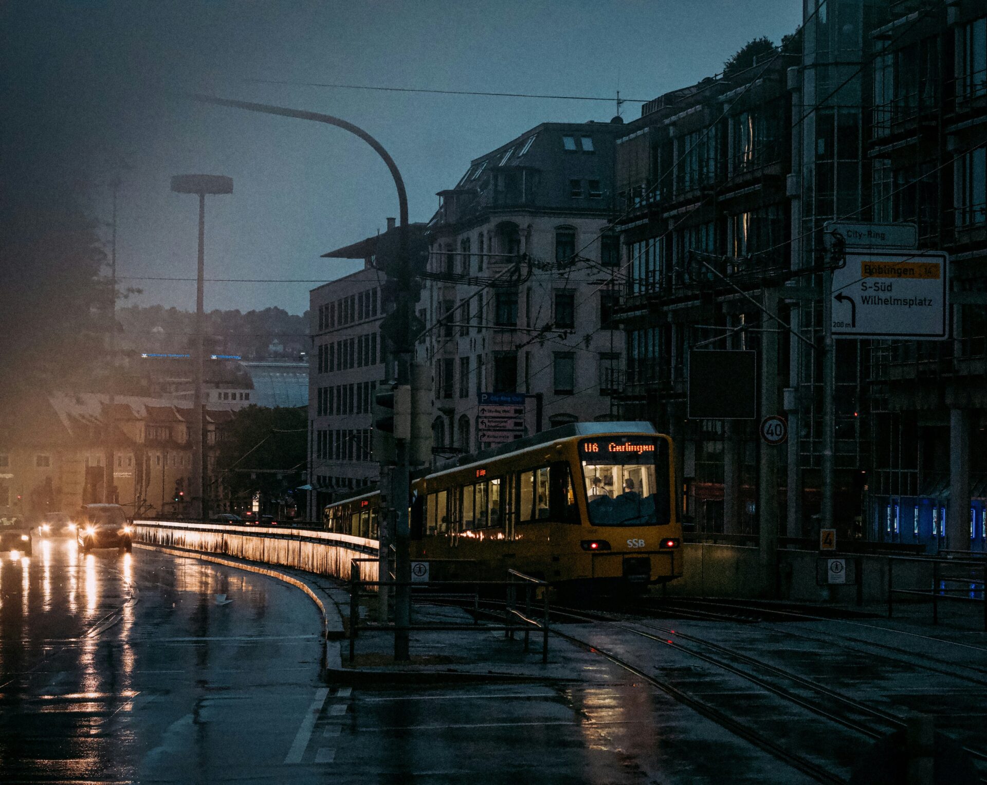 Tram train driving into underground station during rainy summer storm in the evening in Stuttgart